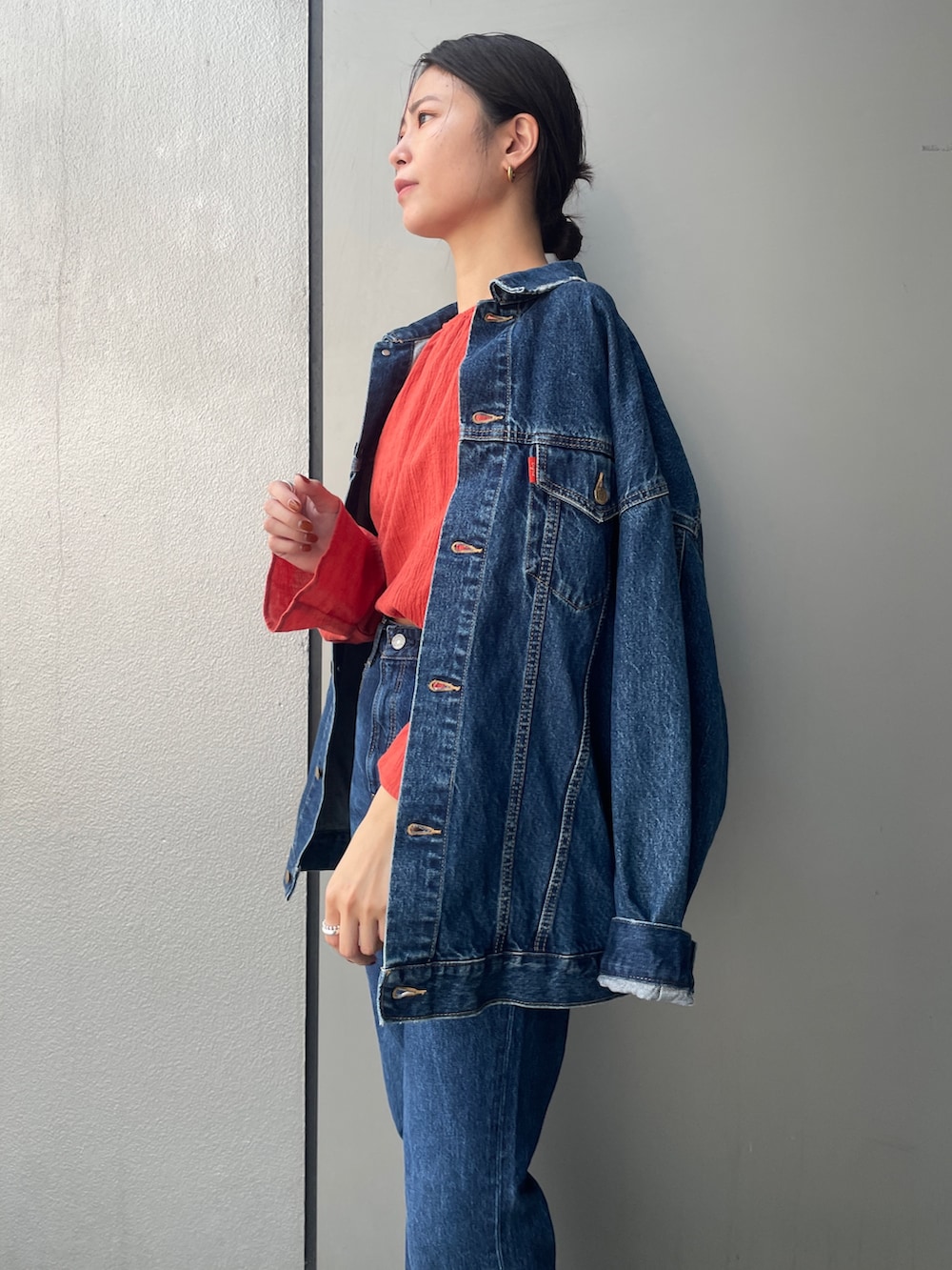 ブルー系のデニムパンツ、オレンジ系のシャツ/ブラウス、ブルー系のデニムジャケットを着用したレディースの夏コーディネートの5枚目の写真