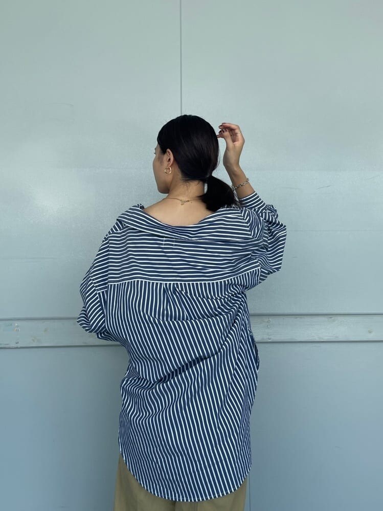 ホワイト系のキャミソール、ブルー系のシャツ/ブラウス、ベージュ系のチノパンツを着用したレディースの夏コーディネートの3枚目の写真