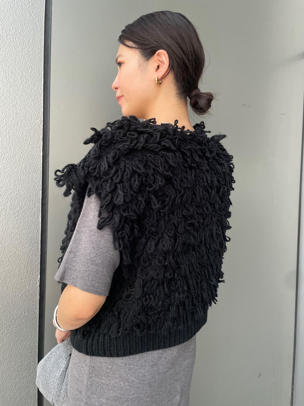 グレー系のワンピース、ブラック系のブーツ、ホワイト系のハンドバッグを着用したレディースの秋コーディネートの6枚目の写真