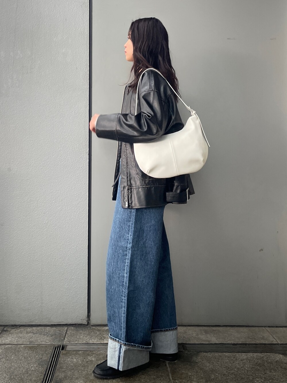 ブルー系のデニムパンツ、ブラック系のブルゾン、ブラック系のローファーを着用したレディースの冬コーディネートの3枚目の写真