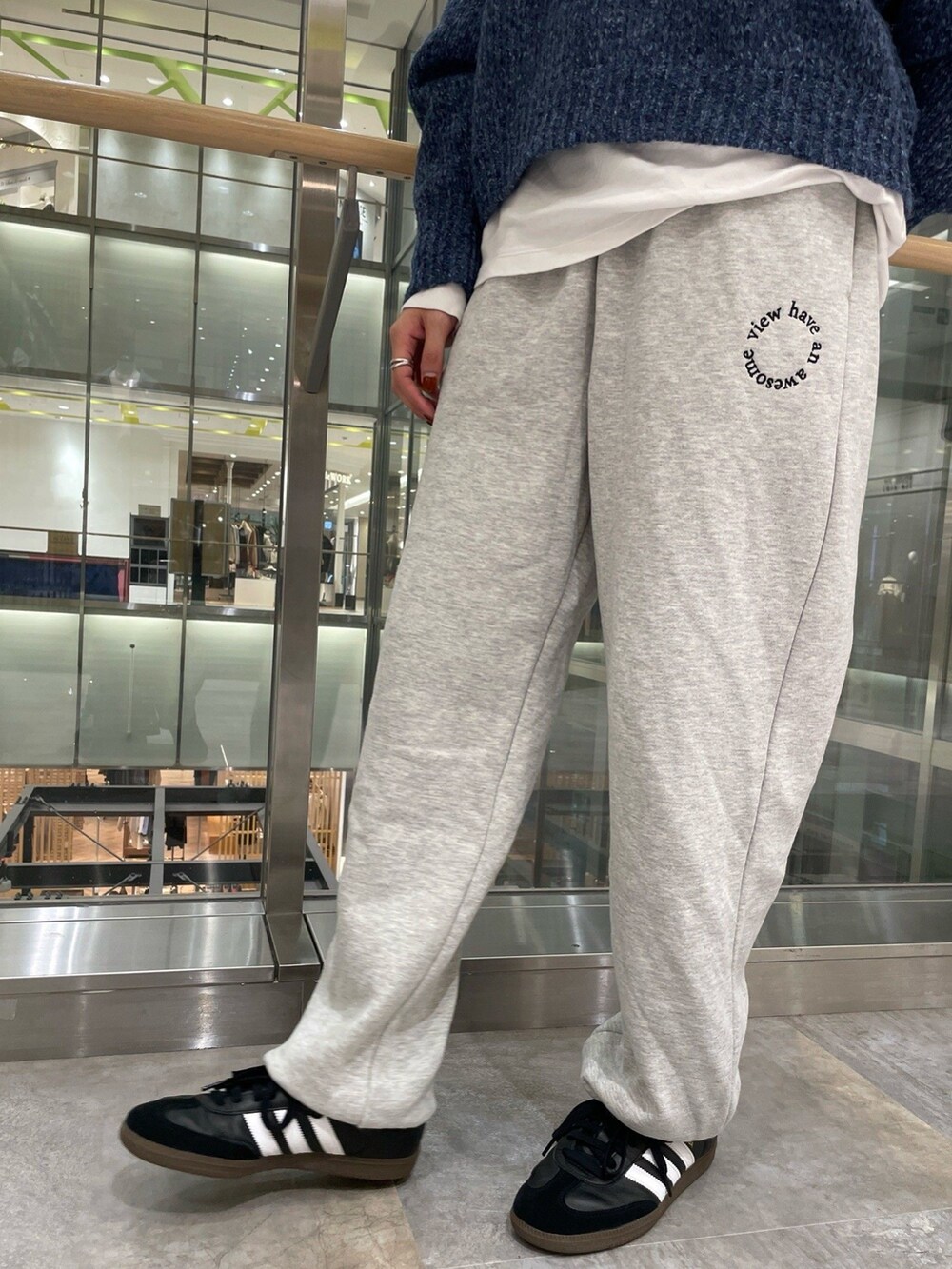 ブルー系のニット/セーター、ホワイト系のTシャツ/カットソー、グレー系のスウェットパンツを着用したレディースの秋コーディネートの5枚目の写真