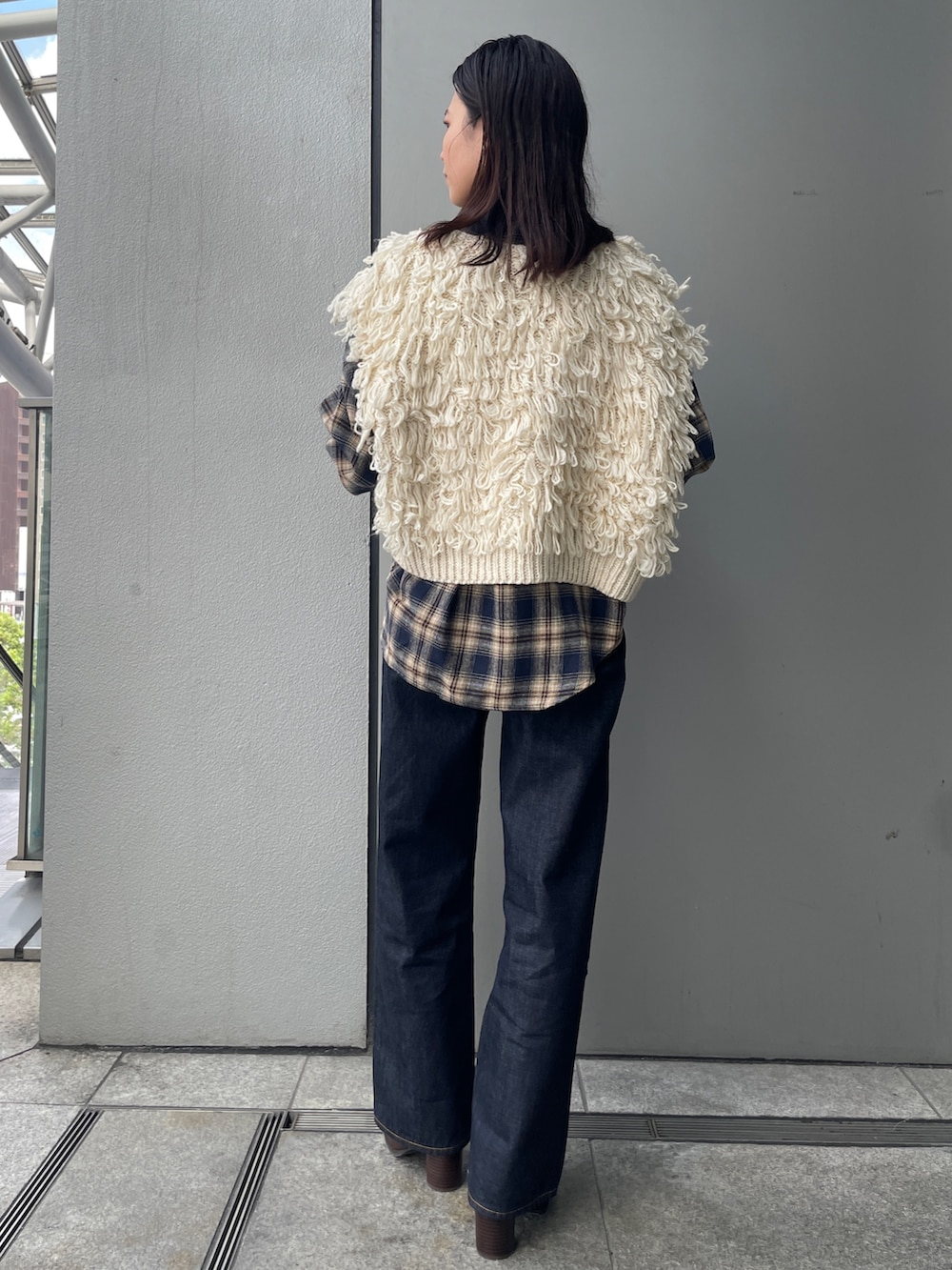 ブルー系のデニムパンツ、ブルー系のシャツ/ブラウス、ホワイト系のベストを着用したレディースの秋コーディネートの3枚目の写真