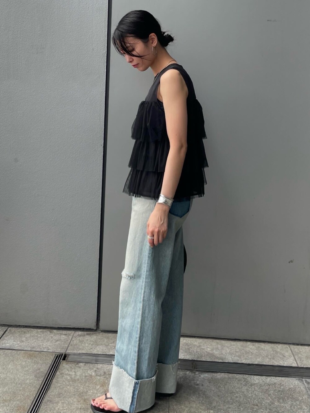 ブラック系のシャツ/ブラウス、ブルー系のデニムパンツを着用したレディースの夏コーディネートの2枚目の写真