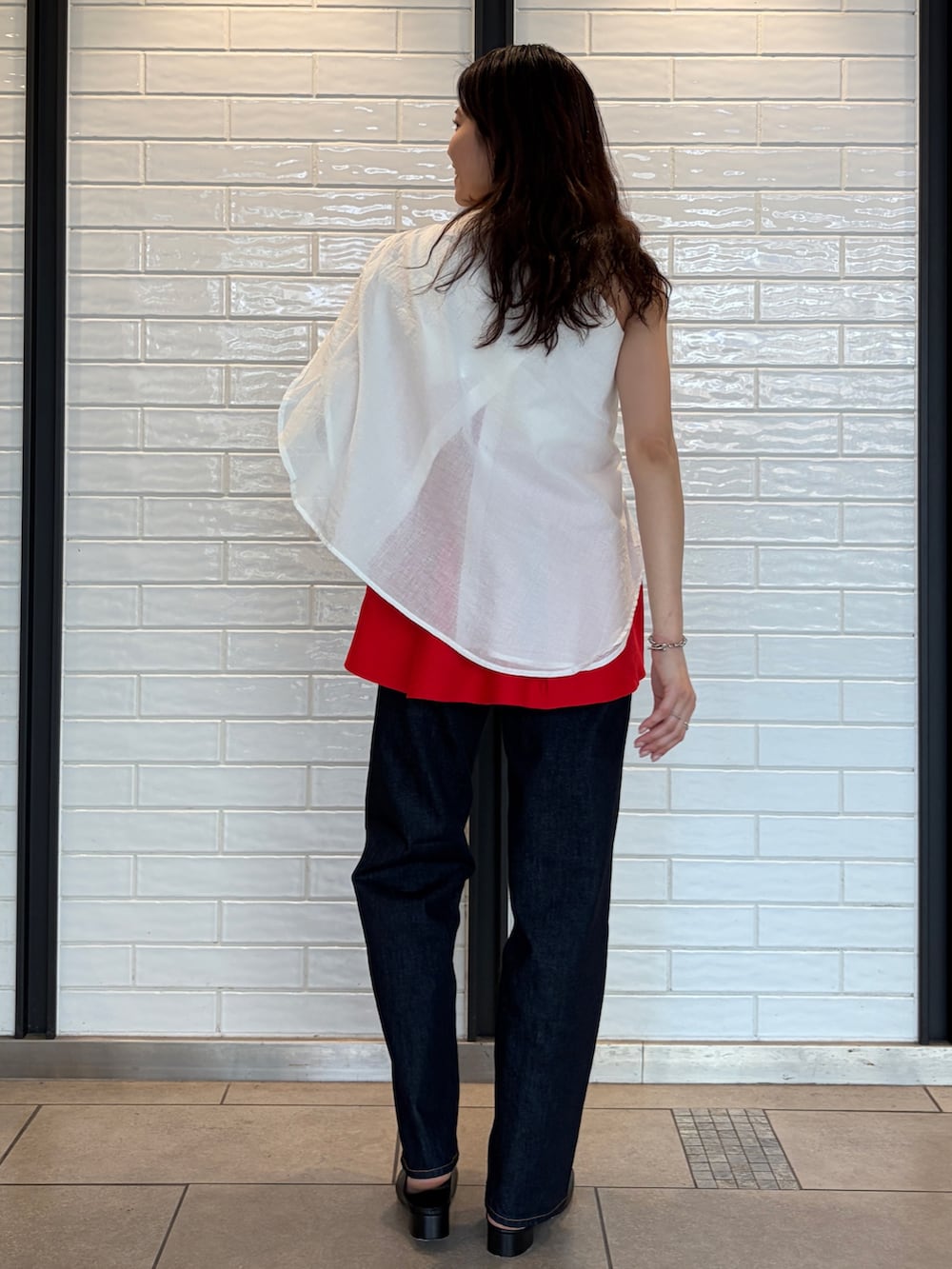 ホワイト系のシャツ/ブラウス、レッド系のキャミソール、ブルー系のデニムパンツを着用したレディースの春コーディネートの2枚目の写真