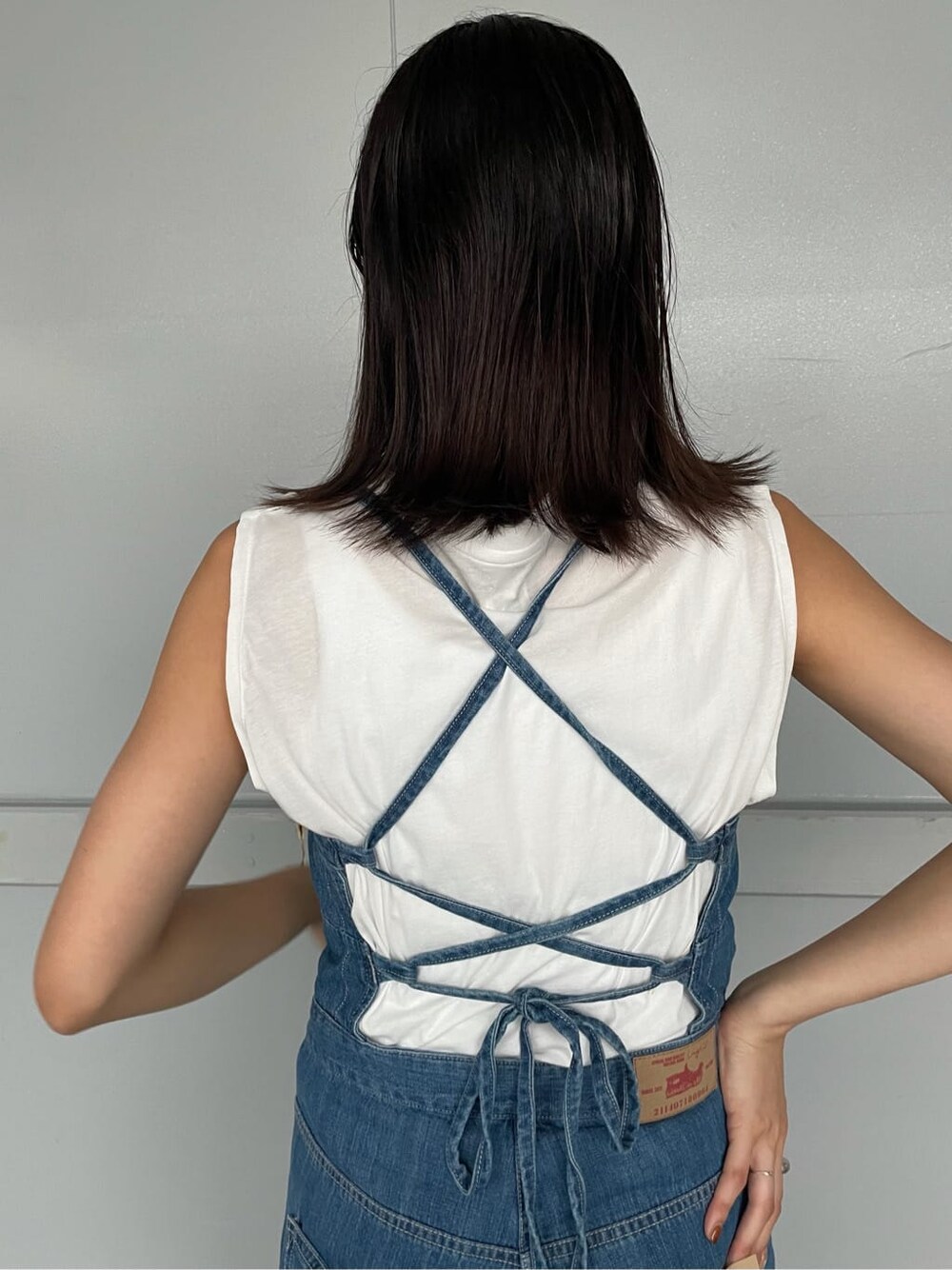 ブラウン系のブーツ、ホワイト系のステンカラーコート、ホワイト系のTシャツ/カットソーを着用したレディースの夏コーディネートの3枚目の写真