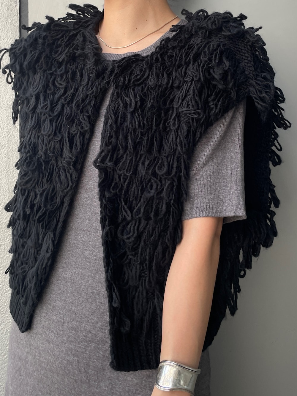 グレー系のワンピース、ブラック系のブーツ、ホワイト系のハンドバッグを着用したレディースの秋コーディネートの5枚目の写真