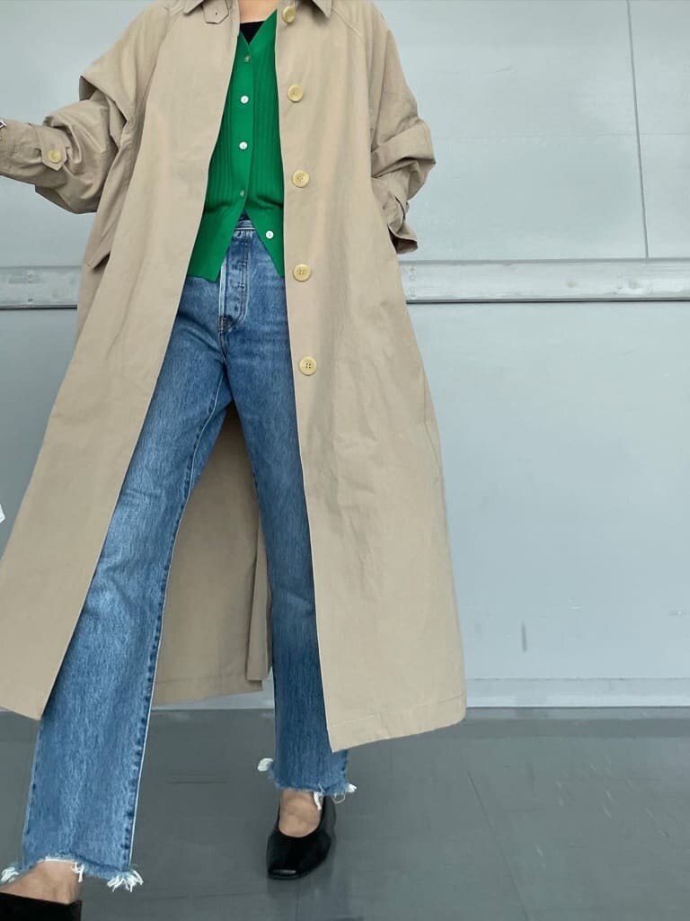 ブラック系のパンプス、ベージュ系のステンカラーコート、グリーン系のカーディガン/ボレロを着用したレディースの夏コーディネートの2枚目の写真