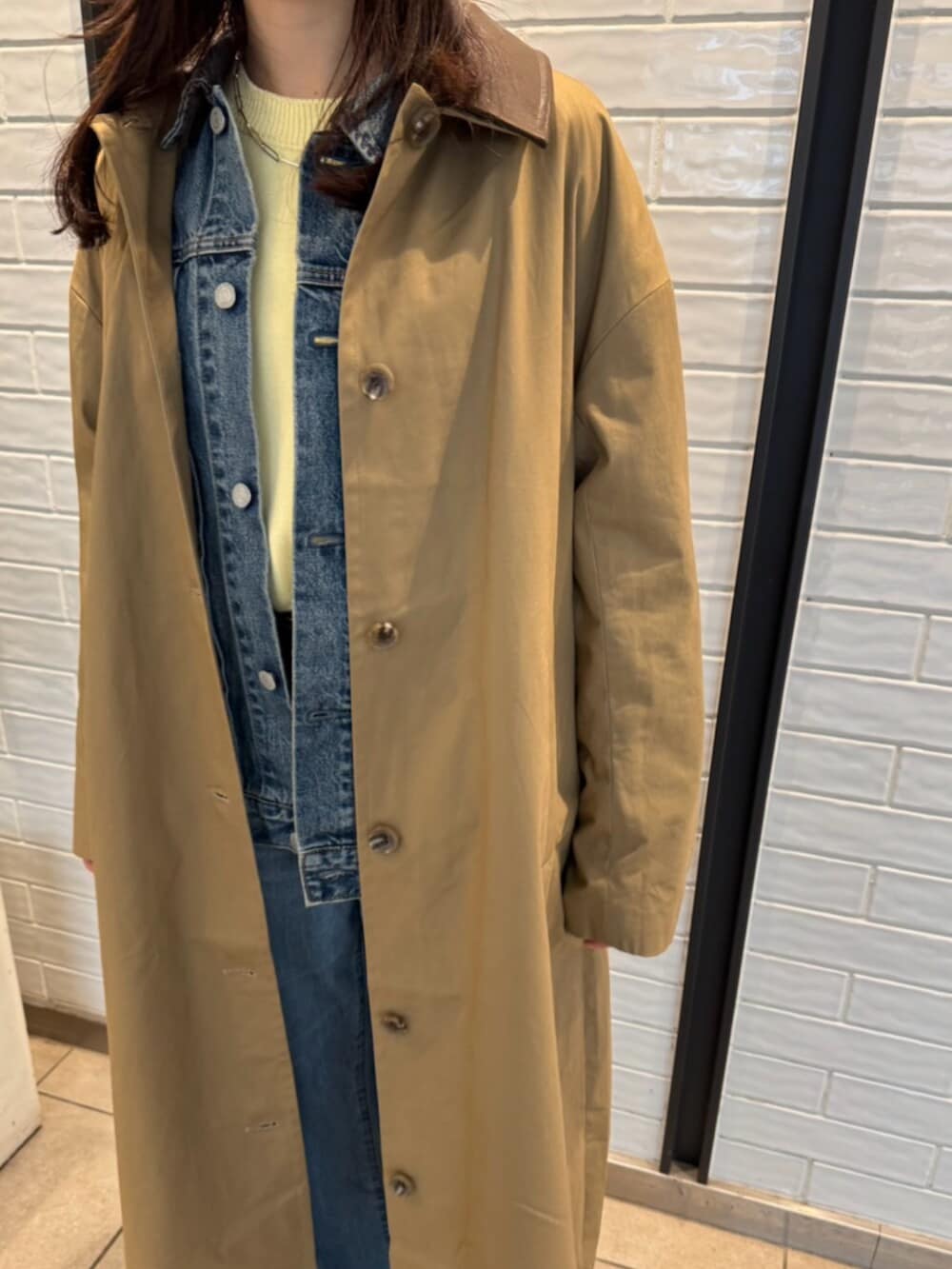 ブルー系のデニムパンツ、ブルー系のデニムジャケット、イエロー系のニット/セーターを着用したレディースの冬コーディネートの6枚目の写真