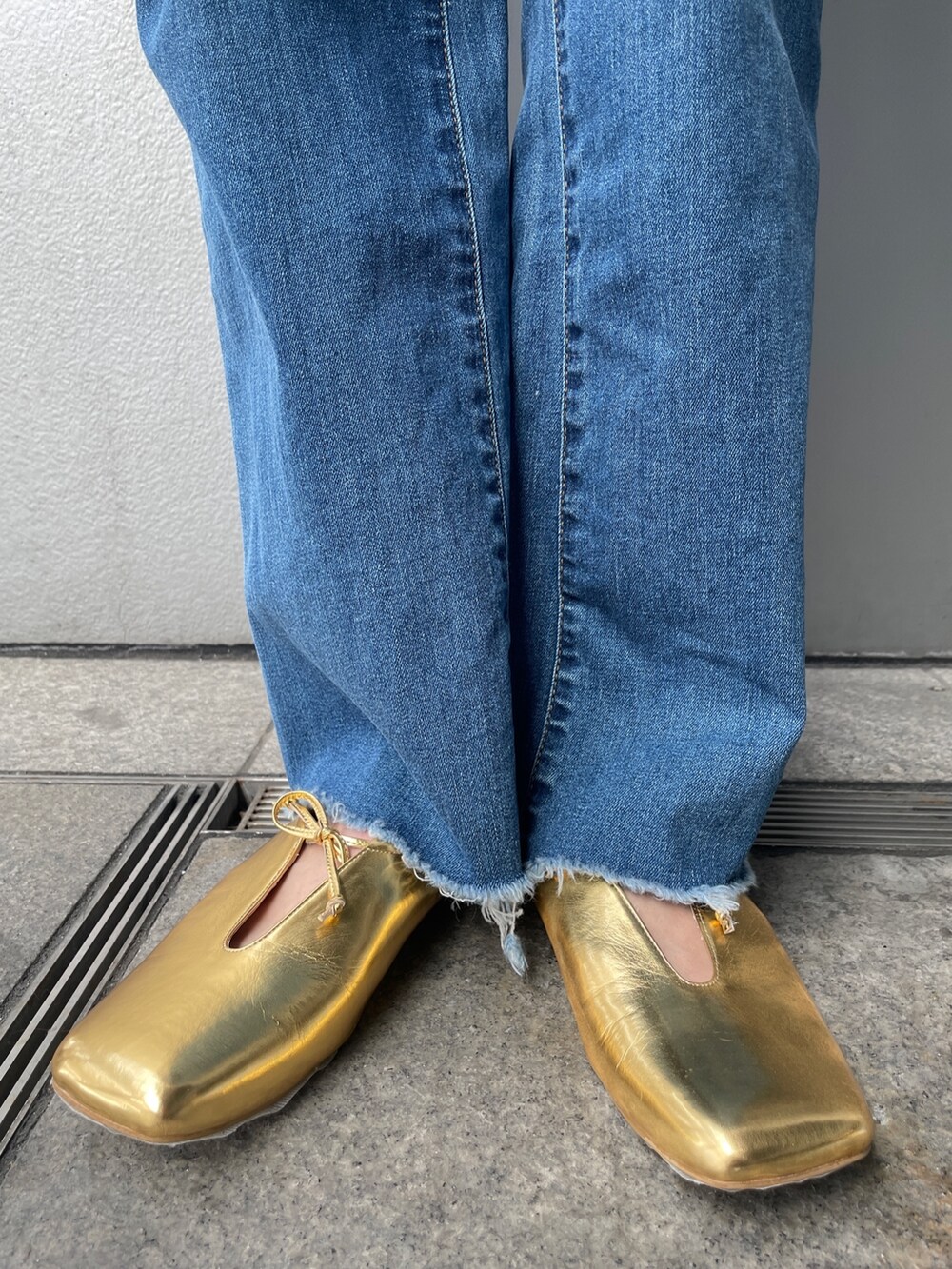 ブルー系のデニムパンツ、ホワイト系のシャツ/ブラウス、ゴールド系のパンプスを着用したレディースの春コーディネートの4枚目の写真