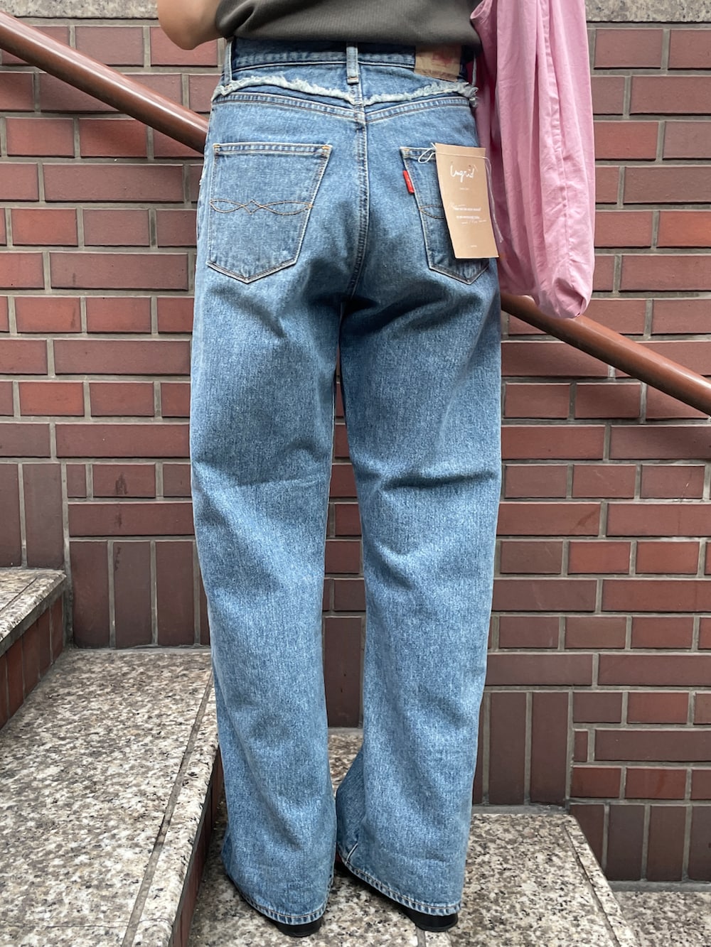 ピンク系のトートバッグ、ブルー系のデニムパンツ、グレー系のタンクトップを着用したレディースの夏コーディネートの6枚目の写真