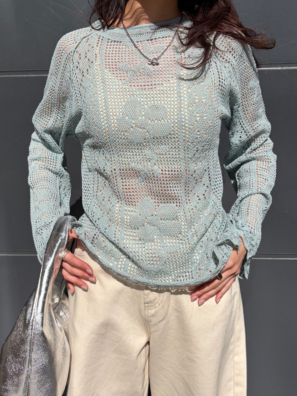 ブルー系のニット/セーター、ホワイト系のデニムパンツ、シルバー系のハンドバッグを着用したレディースの春コーディネートの4枚目の写真