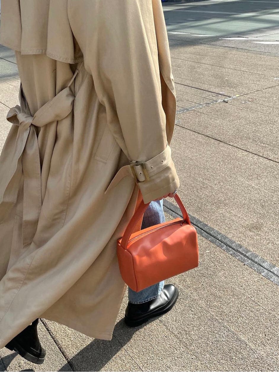 ブルー系のTシャツ/カットソー、ブルー系のデニムパンツ、オレンジ系のハンドバッグを着用したレディースの冬コーディネートの3枚目の写真