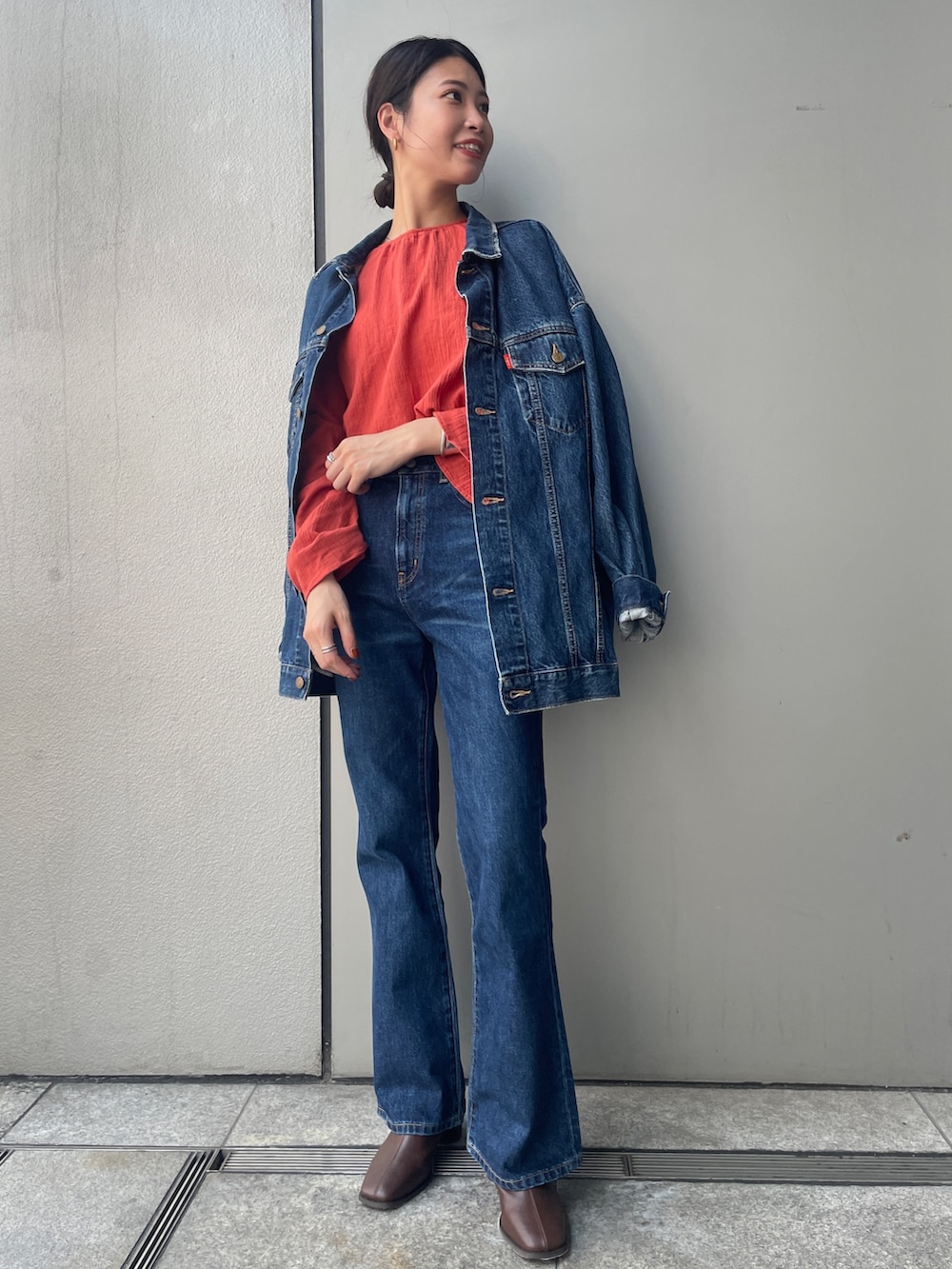 ブルー系のデニムパンツ、オレンジ系のシャツ/ブラウス、ブルー系のデニムジャケットを着用したレディースの夏コーディネートの4枚目の写真