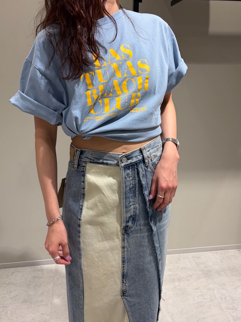 ブルー系のデニムスカート、ブルー系のTシャツ/カットソー、ホワイト系のサンダルを着用したレディースの春コーディネートの4枚目の写真