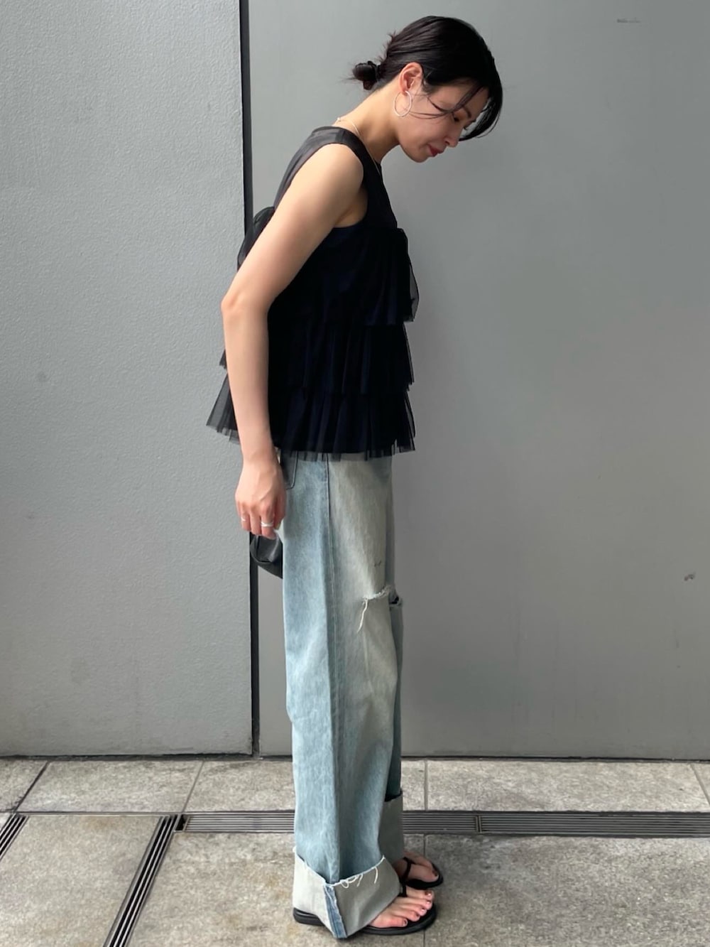 ブラック系のシャツ/ブラウス、ブルー系のデニムパンツを着用したレディースの夏コーディネートの3枚目の写真