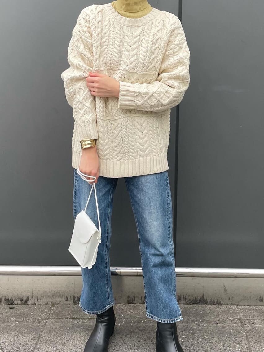 ブルー系のデニムパンツ、イエロー系のニット/セーター、ホワイト系のカーディガン/ボレロを着用したレディースの冬コーディネートの4枚目の写真