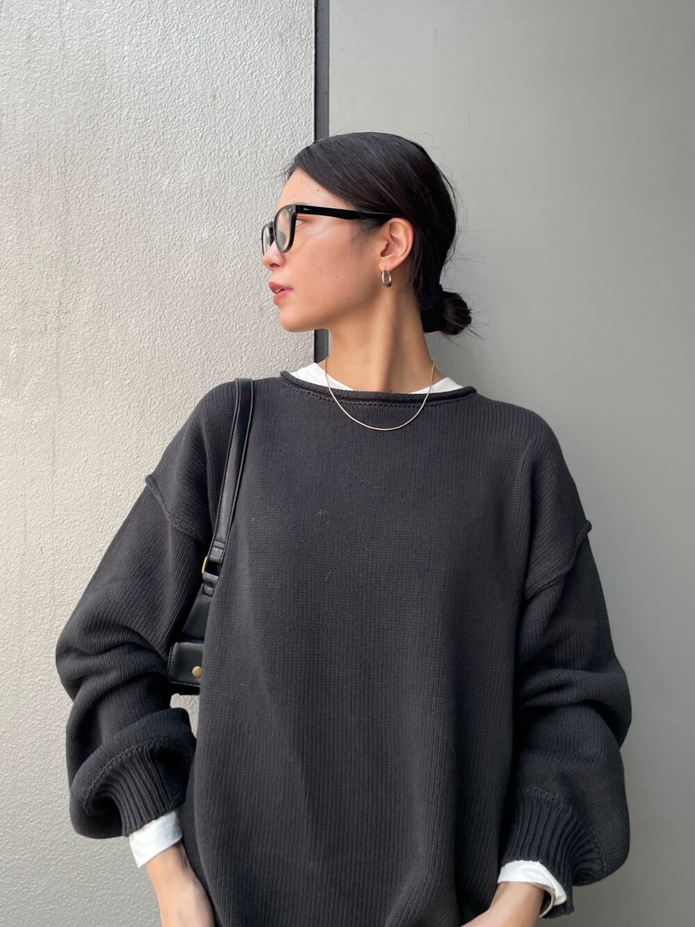 グレー系のニット/セーター、ホワイト系のTシャツ/カットソー、ホワイト系のスカートを着用したレディースの秋コーディネートの5枚目の写真