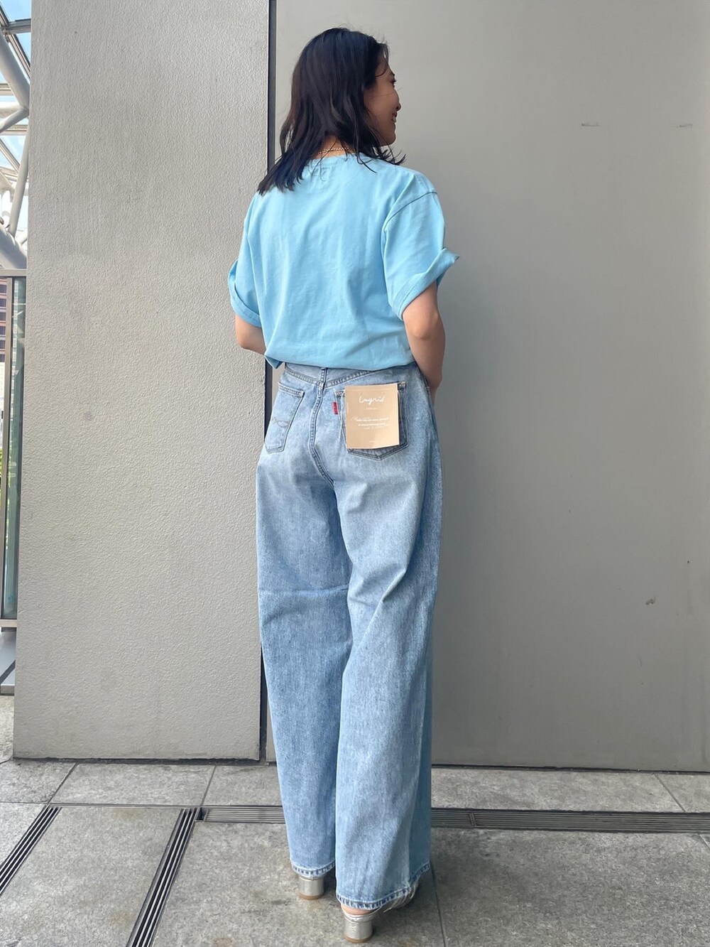 ブルー系のデニムパンツ、ブルー系のTシャツ/カットソー、シルバー系のサンダルを着用したレディースの夏コーディネートの6枚目の写真