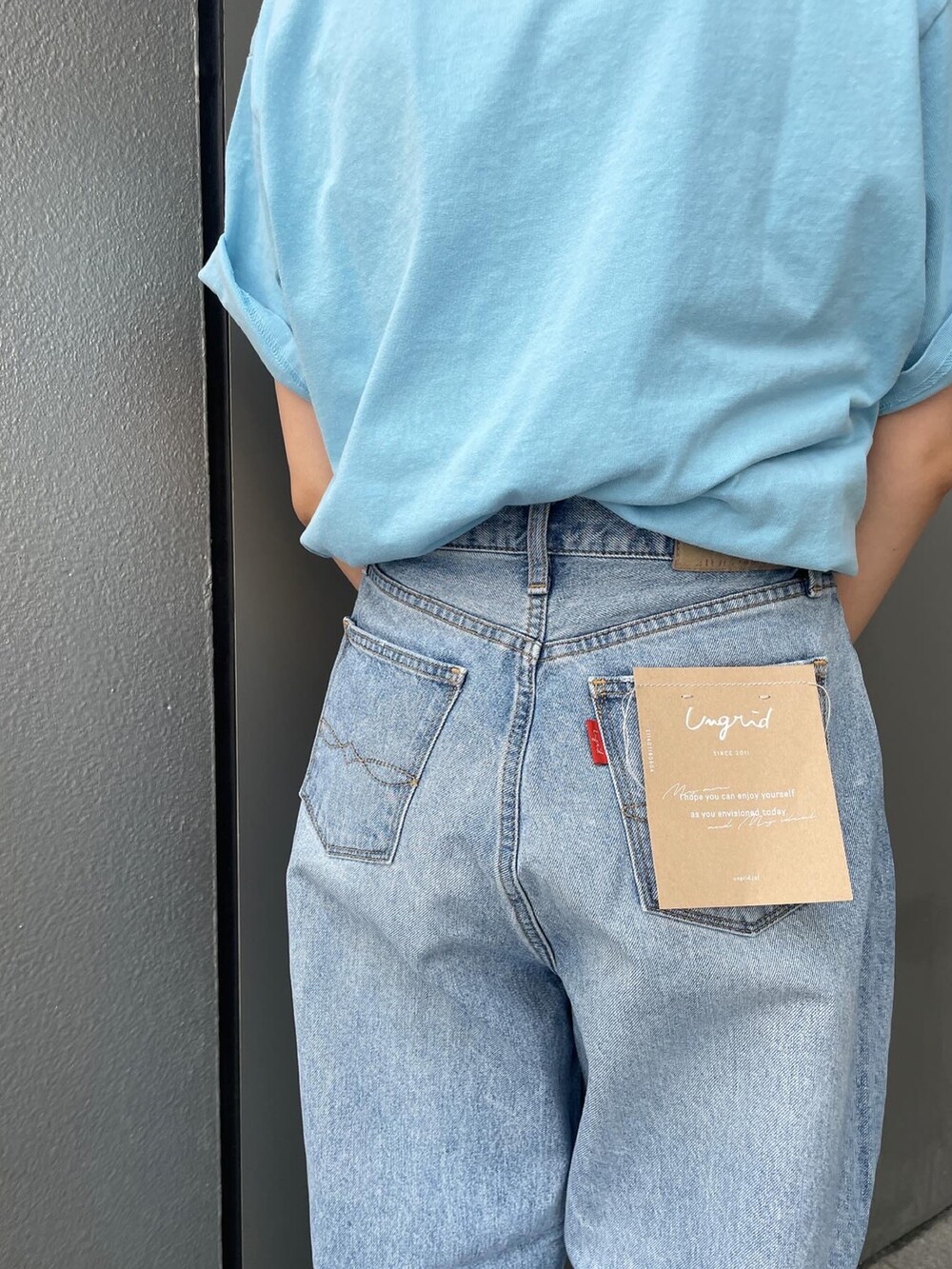 ブルー系のデニムパンツ、ブルー系のTシャツ/カットソー、シルバー系のサンダルを着用したレディースの夏コーディネートの4枚目の写真