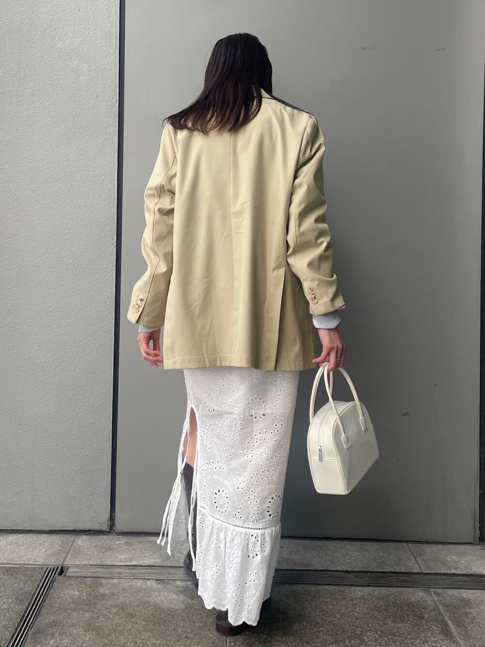 ベージュ系のテーラードジャケット、グレー系のスウェット、ブラウン系のブーツを着用したレディースの冬コーディネートの2枚目の写真