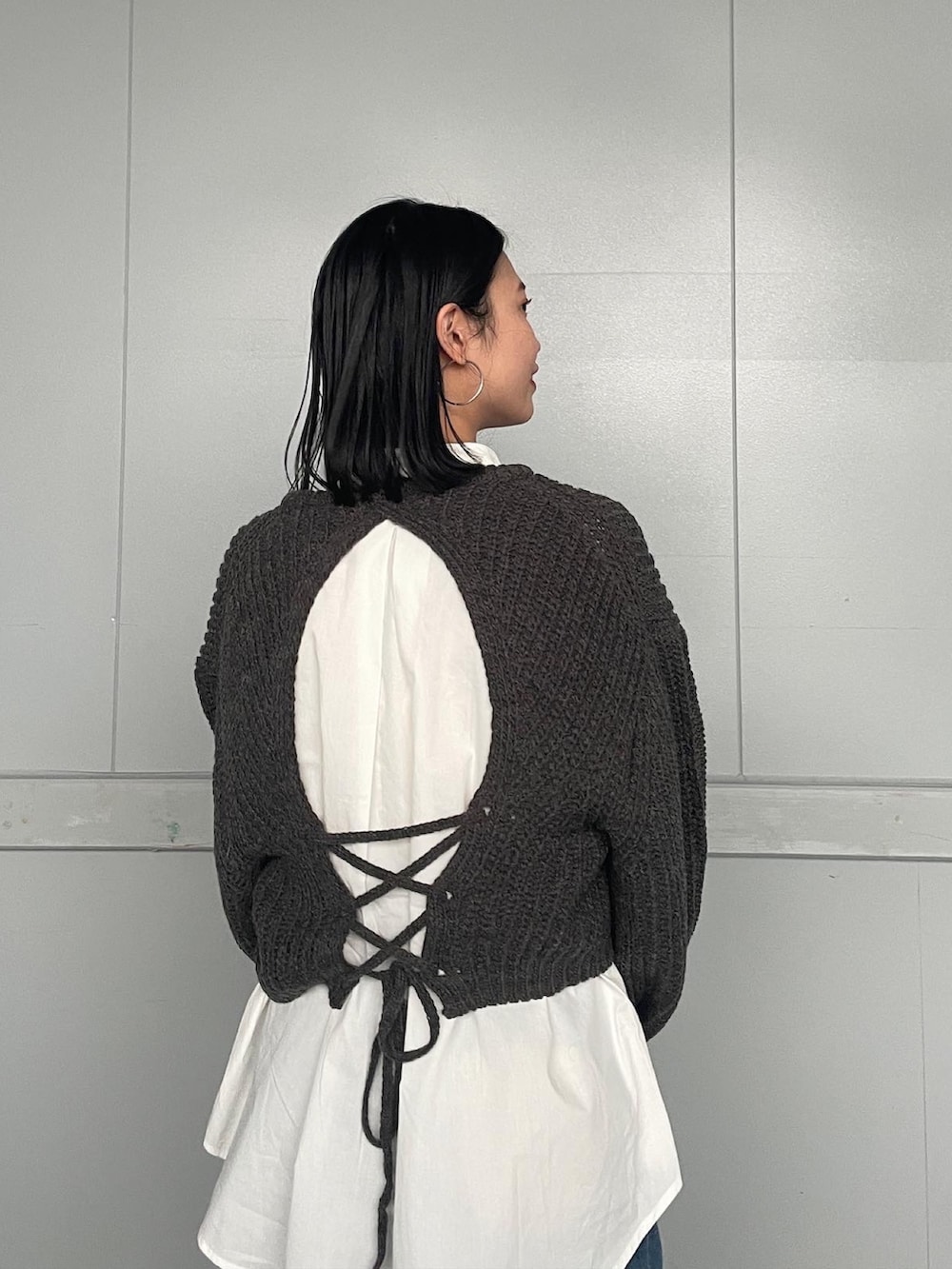 グレー系のニット/セーター、ブルー系のデニムパンツを着用したレディースの冬コーディネートの2枚目の写真