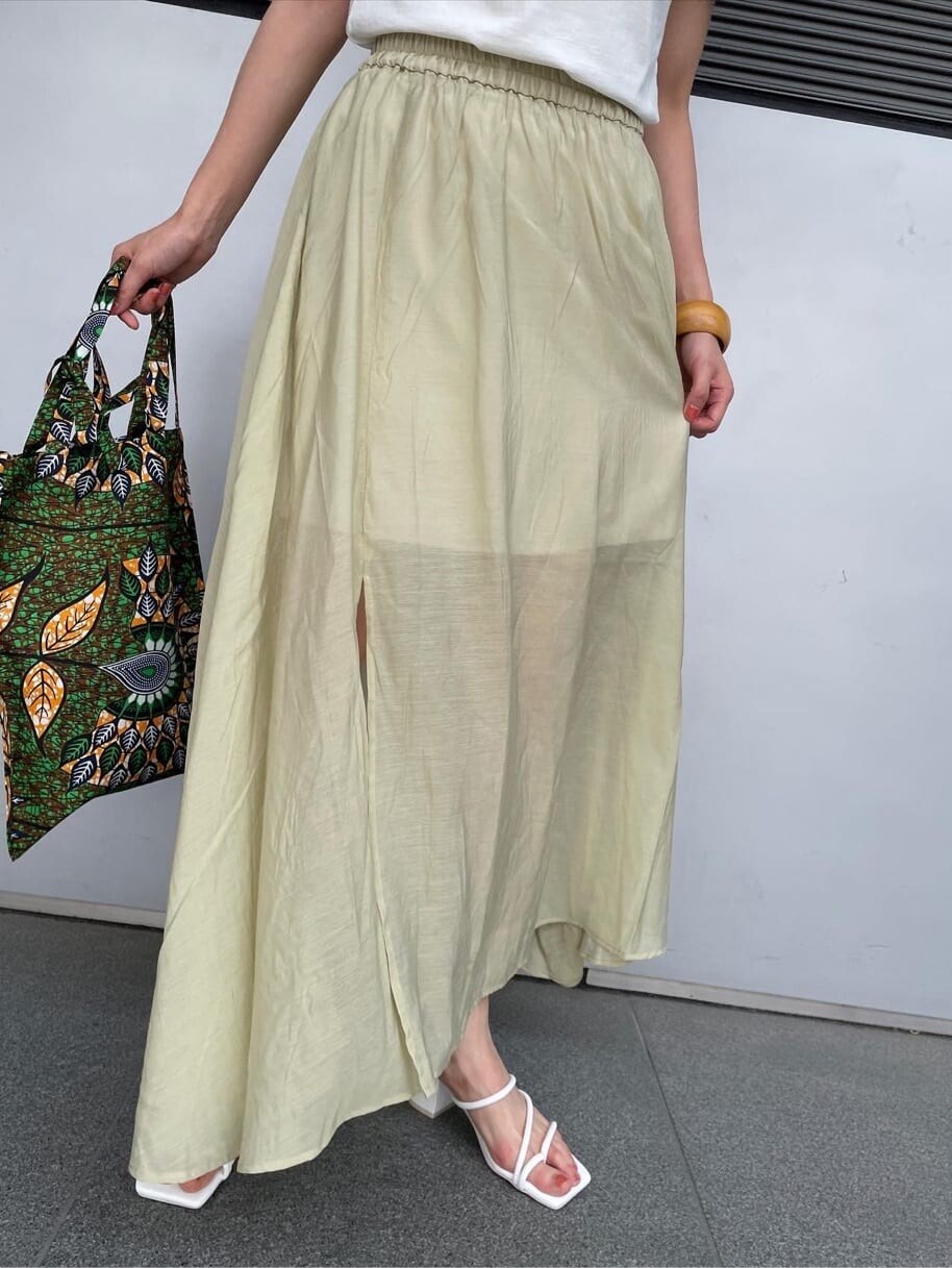 グリーン系のショルダーバッグ、ホワイト系のTシャツ/カットソー、グリーン系のスカートを着用したレディースの春コーディネートの3枚目の写真