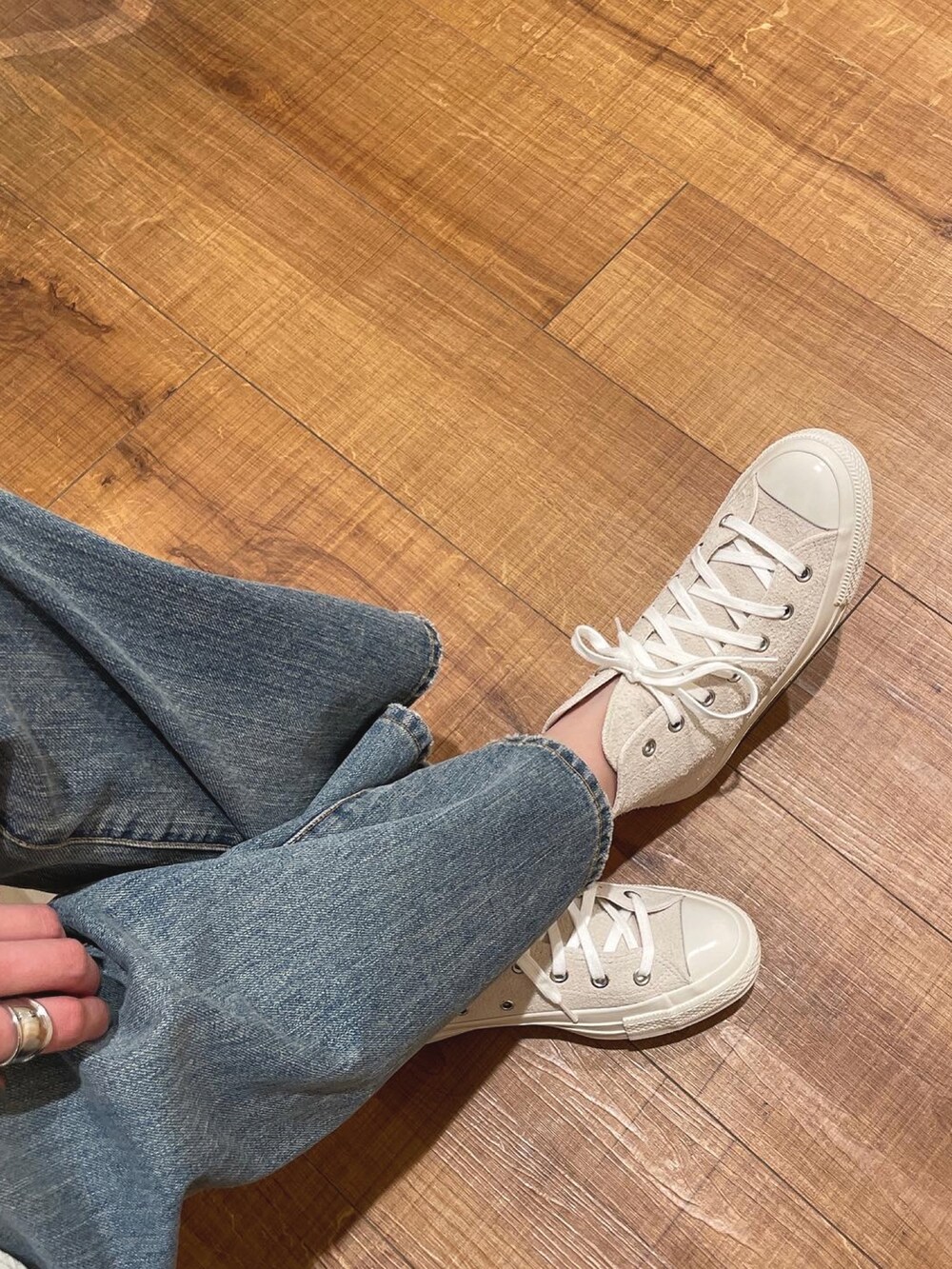 ホワイト系のワンピース、ブルー系のデニムパンツ、ホワイト系のスニーカーを着用したレディースの春コーディネートの2枚目の写真