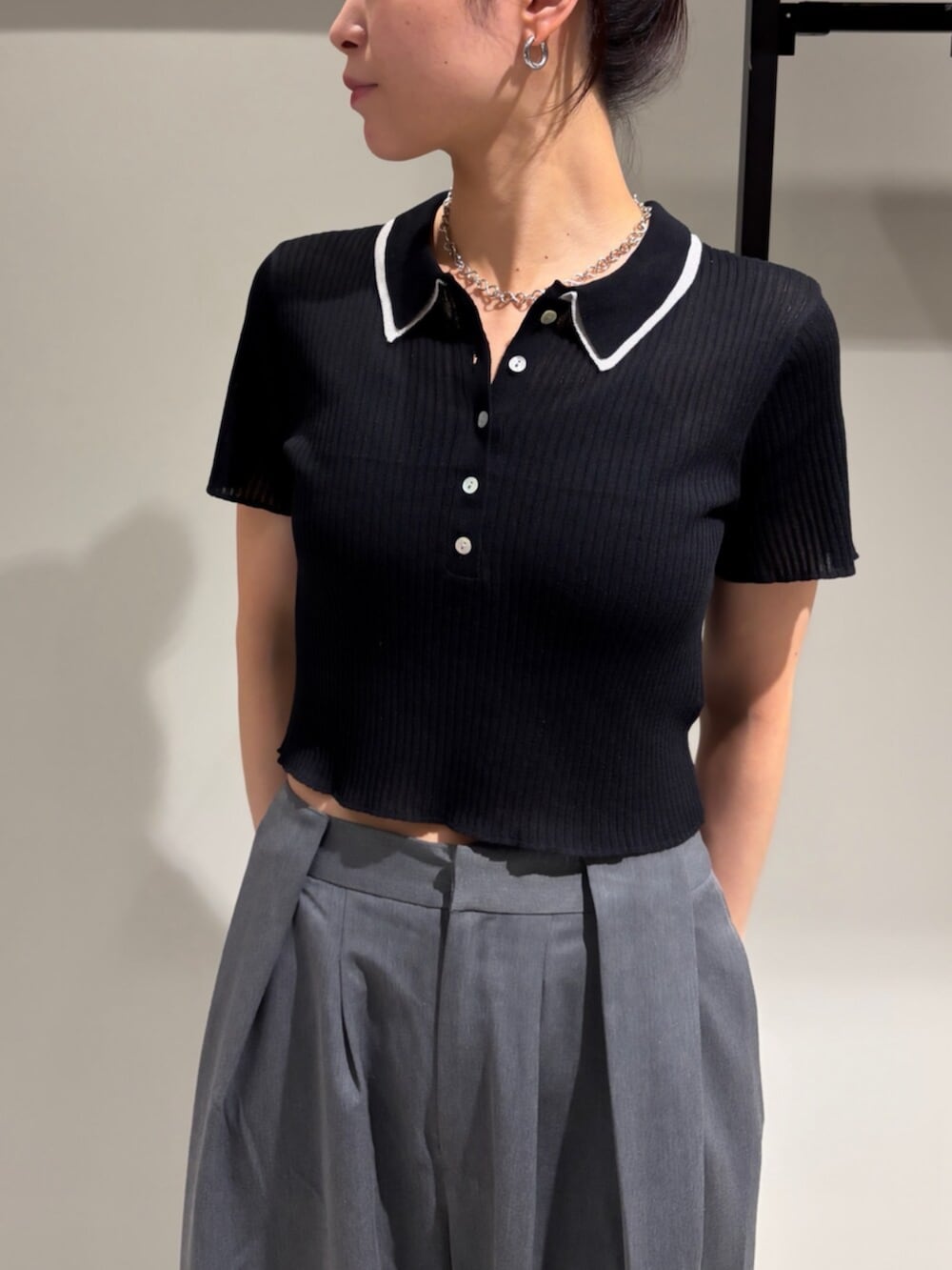 ブラック系のニット/セーター、グレー系のその他パンツ、その他のネックレスを着用したレディースの夏コーディネートの4枚目の写真