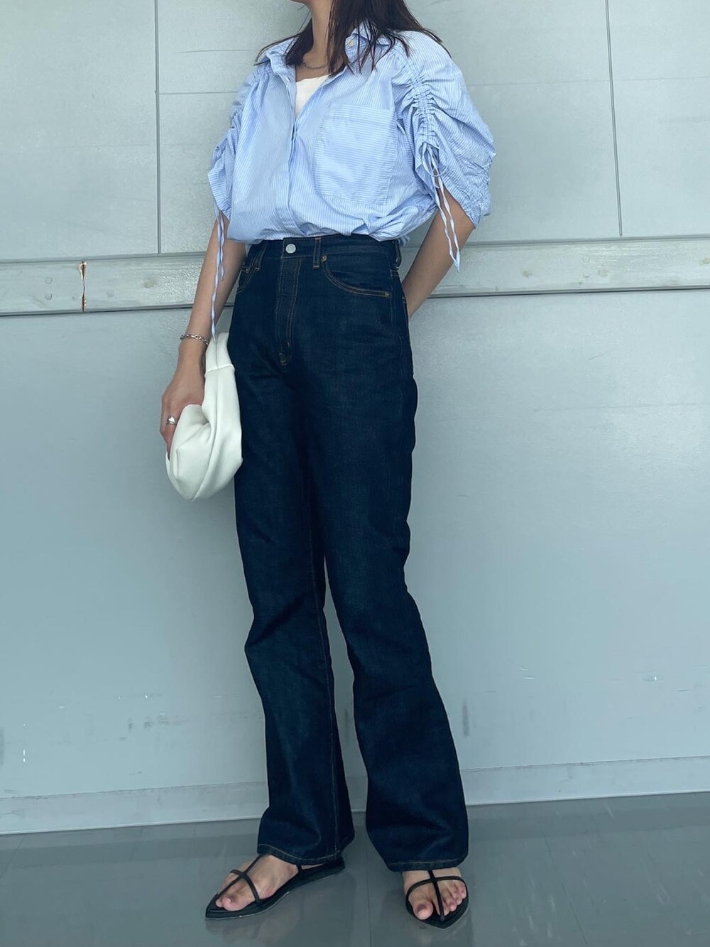 ブルー系のデニムパンツ、ホワイト系のキャミソールを着用したレディースの夏コーディネートの2枚目の写真