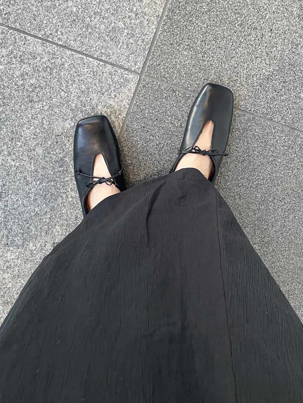 ブラック系のワンピース、ブラック系のパンプスを着用したレディースの春コーディネートの4枚目の写真