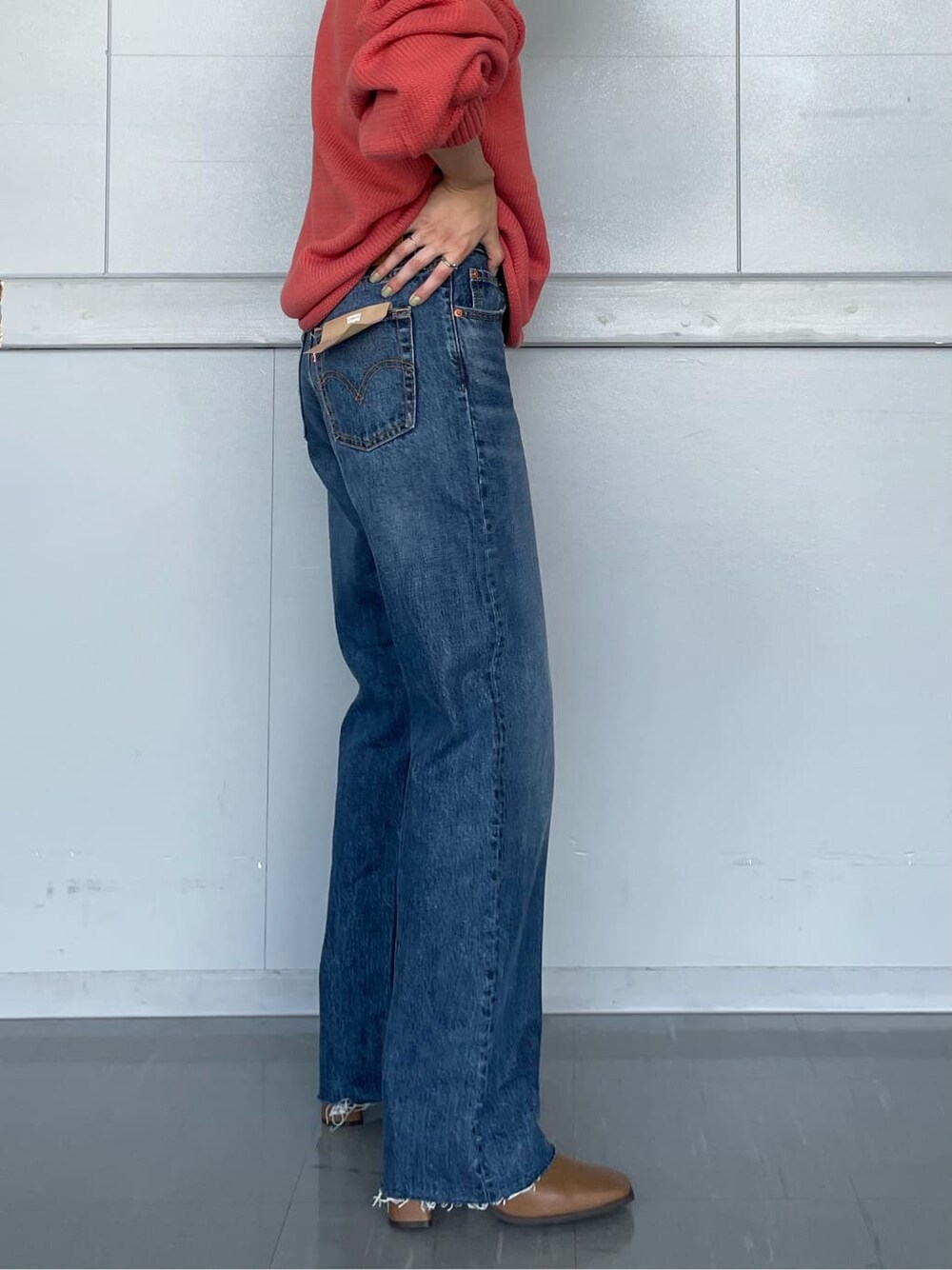 ブラウン系のブーツ、ブルー系のデニムパンツ、ピンク系のニット/セーターを着用したレディースの秋コーディネートの3枚目の写真