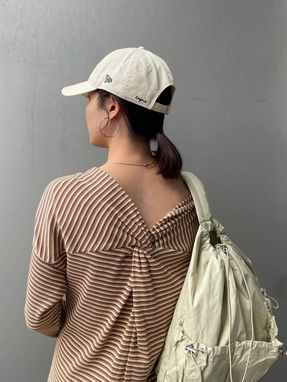 イエロー系のワンピース、ブルー系のデニムジャケット、ベージュ系のバックパック/リュックを着用したレディースの冬コーディネートの3枚目の写真