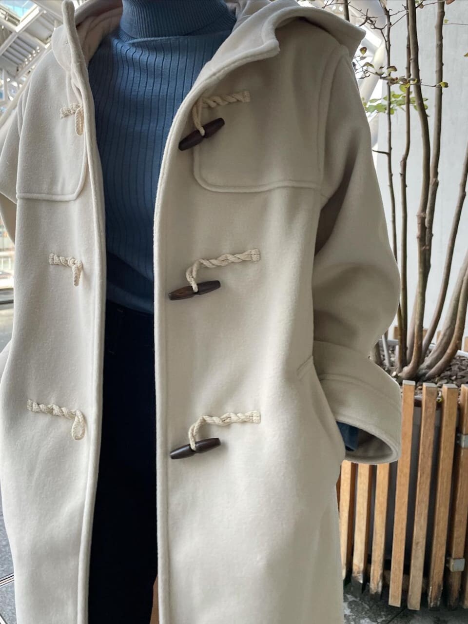 ブルー系のデニムパンツ、ブルー系のニット/セーター、ホワイト系のダッフルコートを着用したレディースの冬コーディネートの2枚目の写真