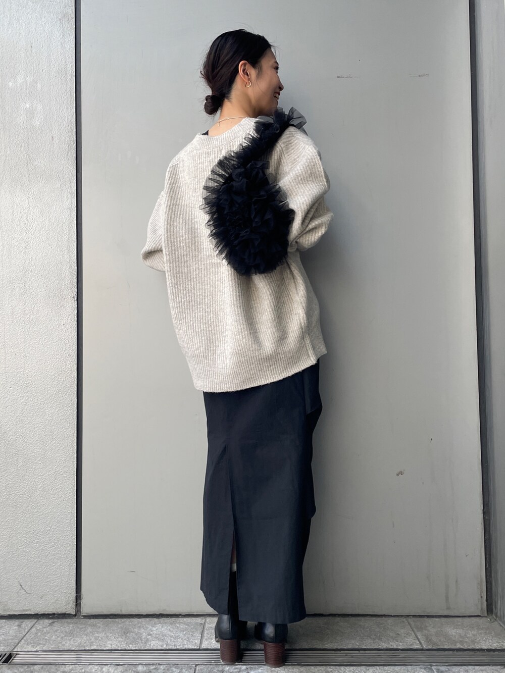 ホワイト系のカーディガン/ボレロ、ブラック系のスカート、ブラック系のTシャツ/カットソーを着用したレディースの秋コーディネートの3枚目の写真