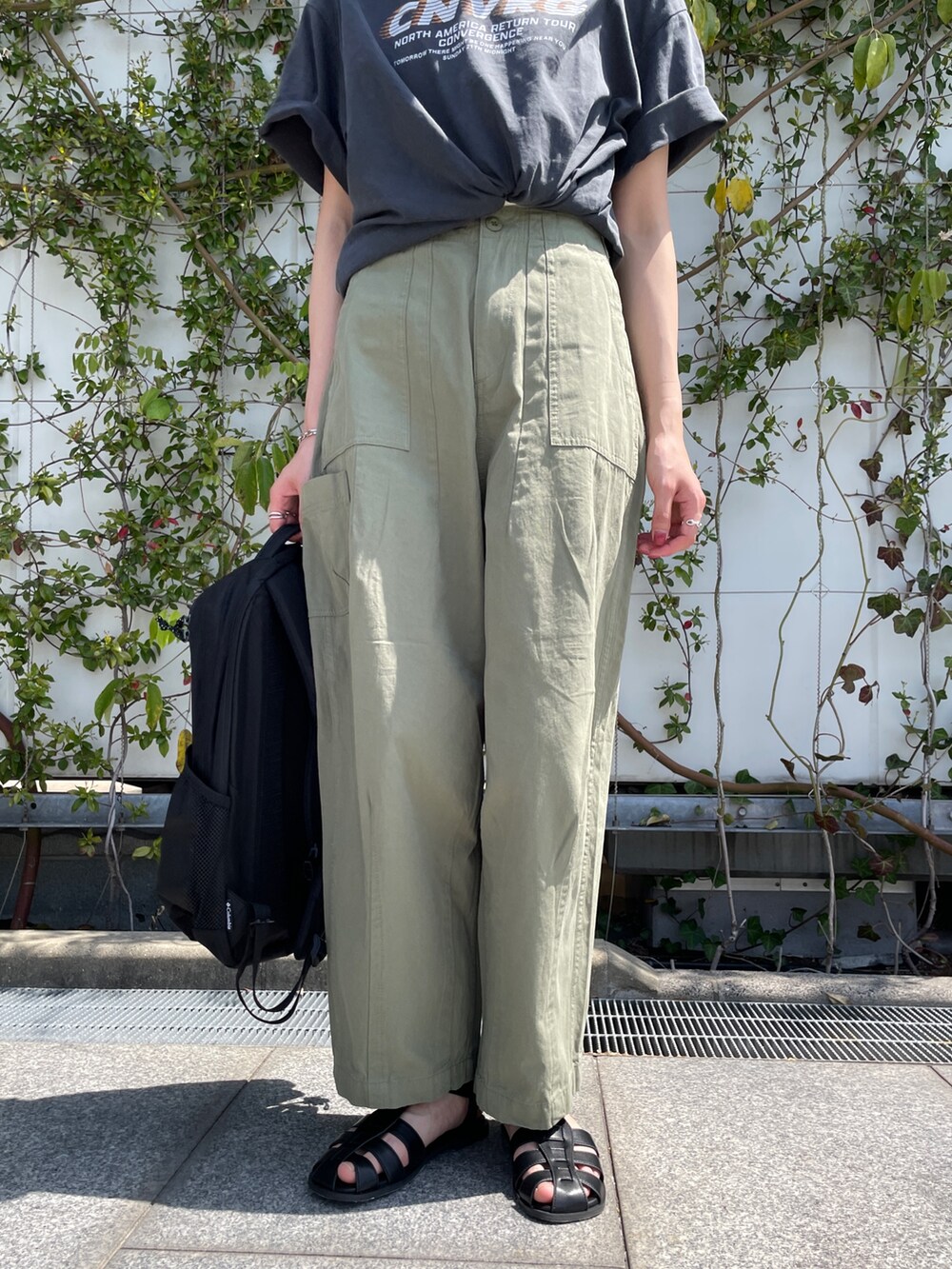 グレー系のTシャツ/カットソー、グリーン系のその他パンツ、ブラック系のサンダルを着用したレディースの春コーディネートの5枚目の写真