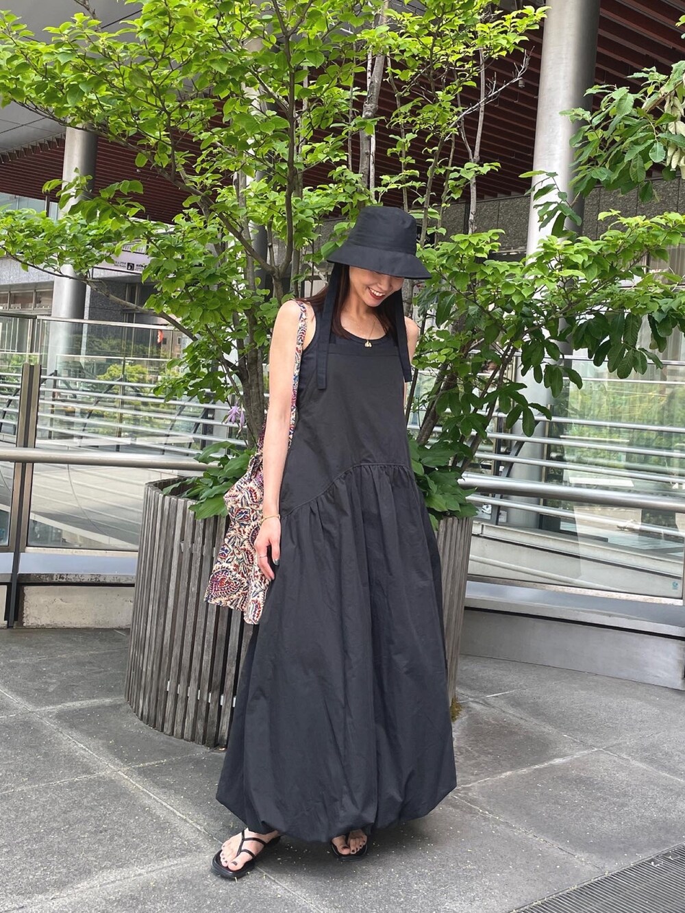ブラック系のワンピース、ブラック系のサンダル、グレー系のタンクトップを着用したレディースの春コーディネートの2枚目の写真