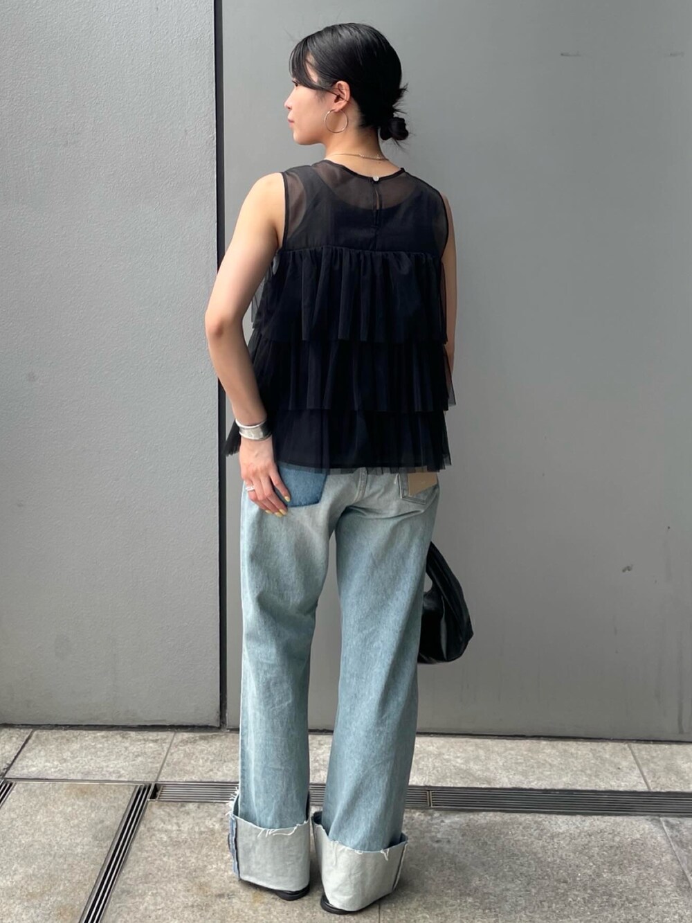 ブラック系のシャツ/ブラウス、ブルー系のデニムパンツを着用したレディースの夏コーディネートの4枚目の写真