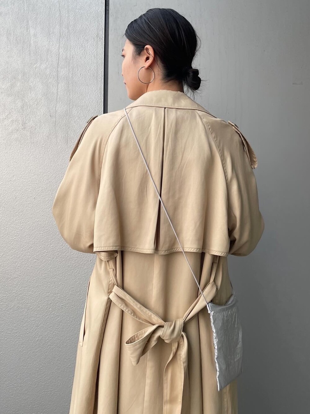 ベージュ系のトレンチコート、イエロー系のシャツ/ブラウス、ブルー系のデニムパンツを着用したレディースの春コーディネートの5枚目の写真