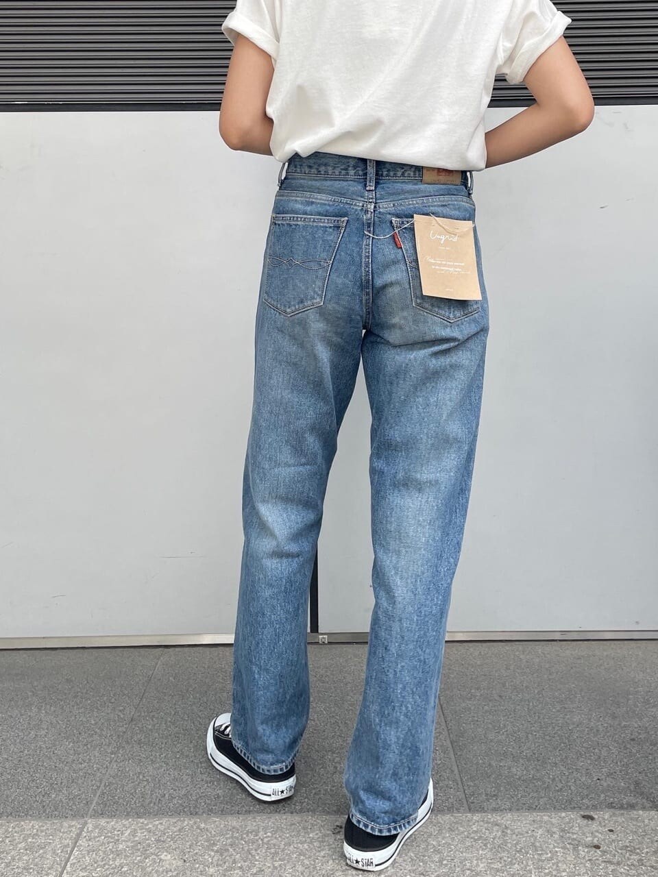 ホワイト系のTシャツ/カットソー、ブルー系のデニムパンツ、ブラウン系のブレスレットを着用したレディースの春コーディネートの2枚目の写真