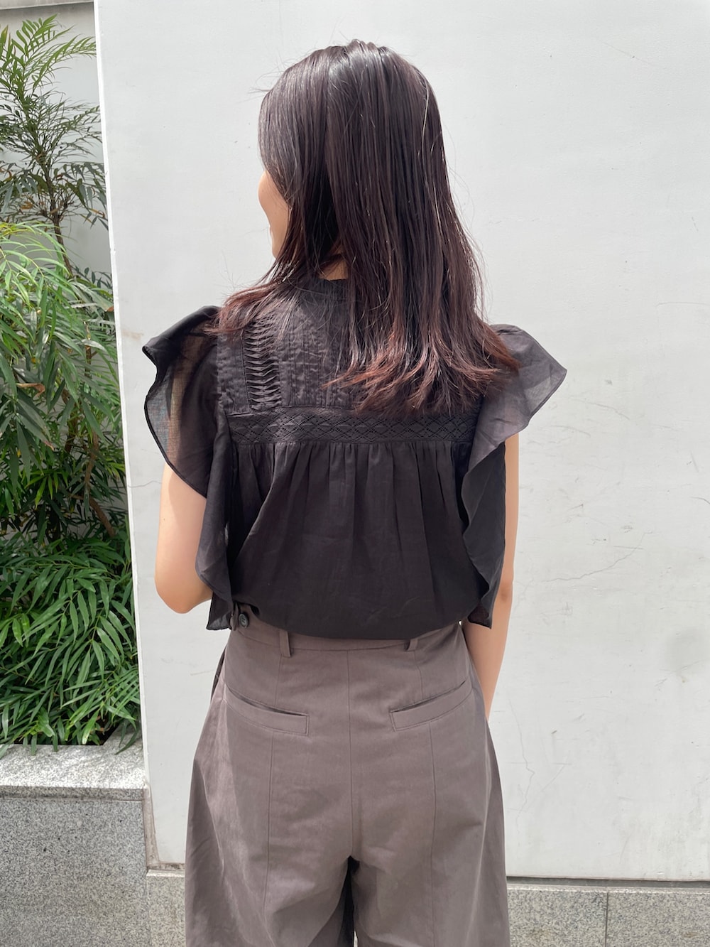 グレー系のチノパンツ、ブラック系のシャツ/ブラウス、シルバー系のサンダルを着用したレディースの春コーディネートの6枚目の写真