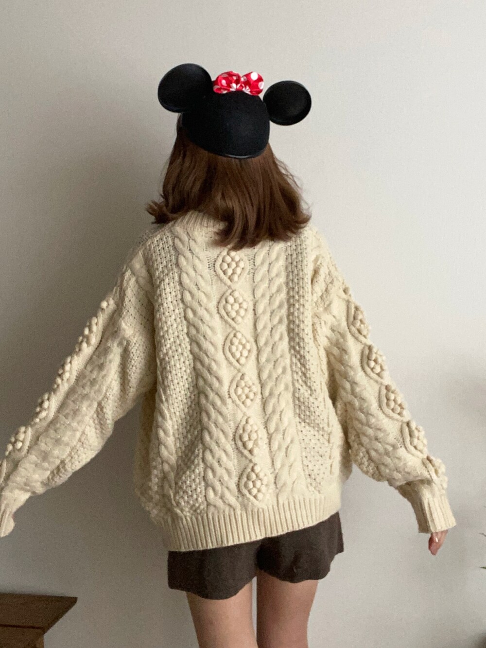 ベージュ系のニット/セーターを着用したレディースの春コーディネートの2枚目の写真