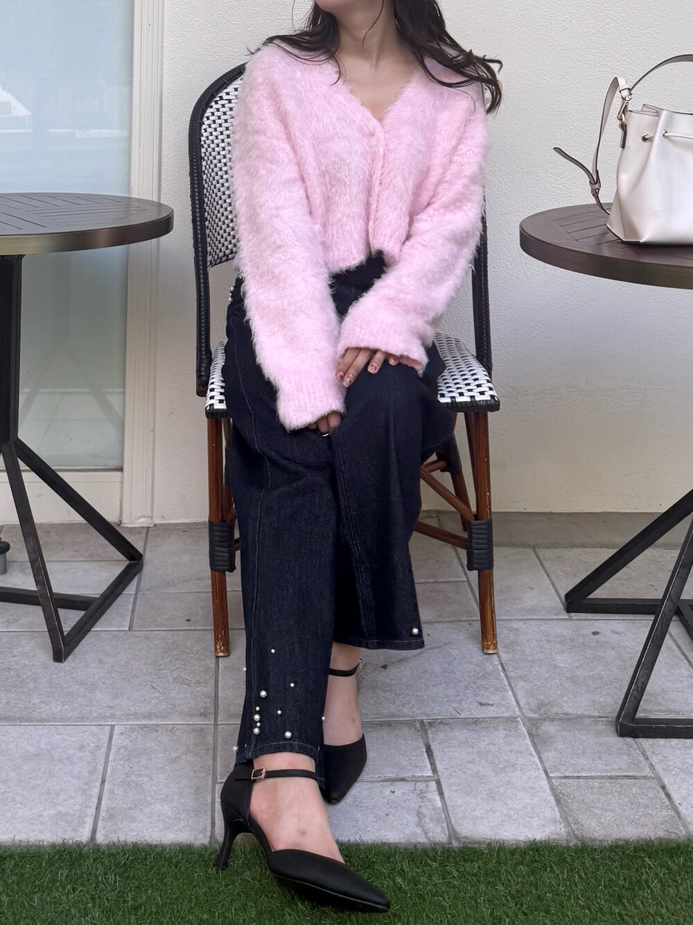 ピンク系のカーディガン/ボレロ、ブルー系のデニムパンツ、ブラック系のパンプスを着用したレディースの秋コーディネートの4枚目の写真