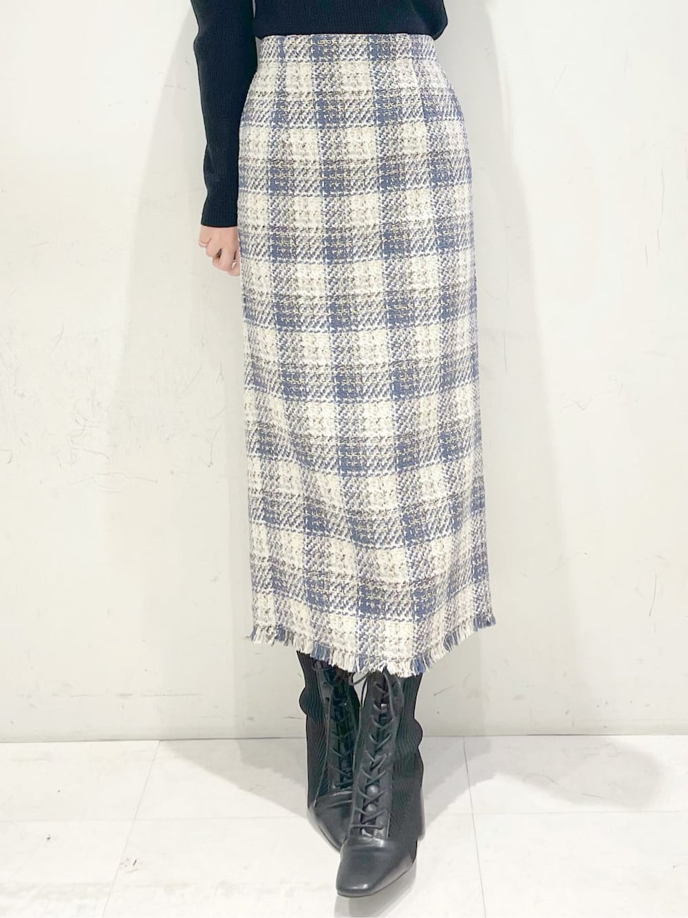 ブラック系のブーツ、ブルー系のスカート、ブラック系のニット/セーターを着用したレディースの冬コーディネートの6枚目の写真