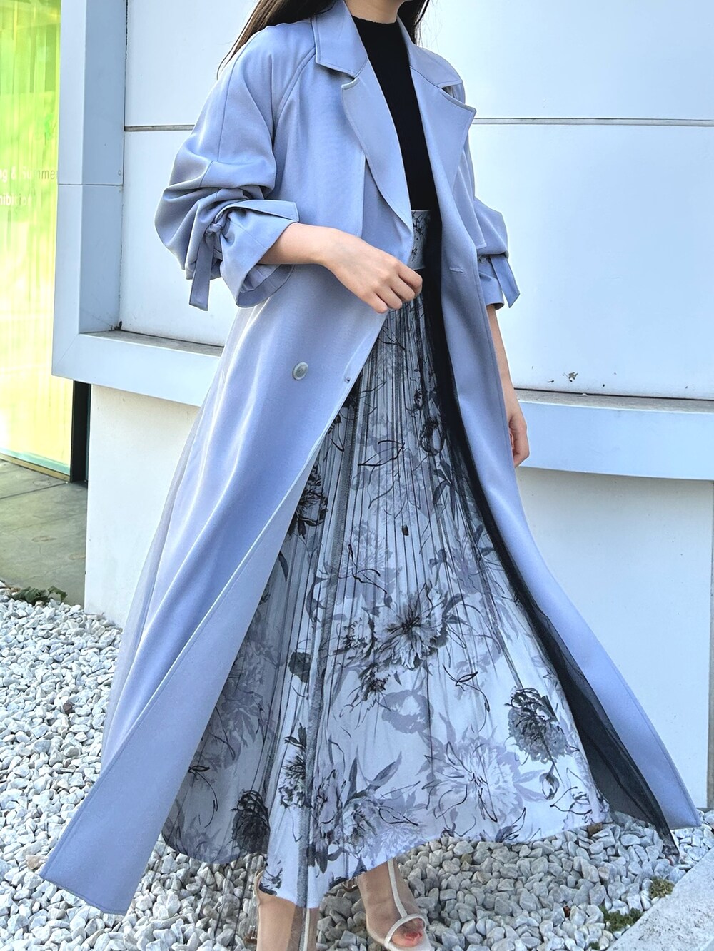 ブルー系のトレンチコート、ブラック系のワンピース、ホワイト系のブーツを着用したレディースの冬コーディネートの6枚目の写真