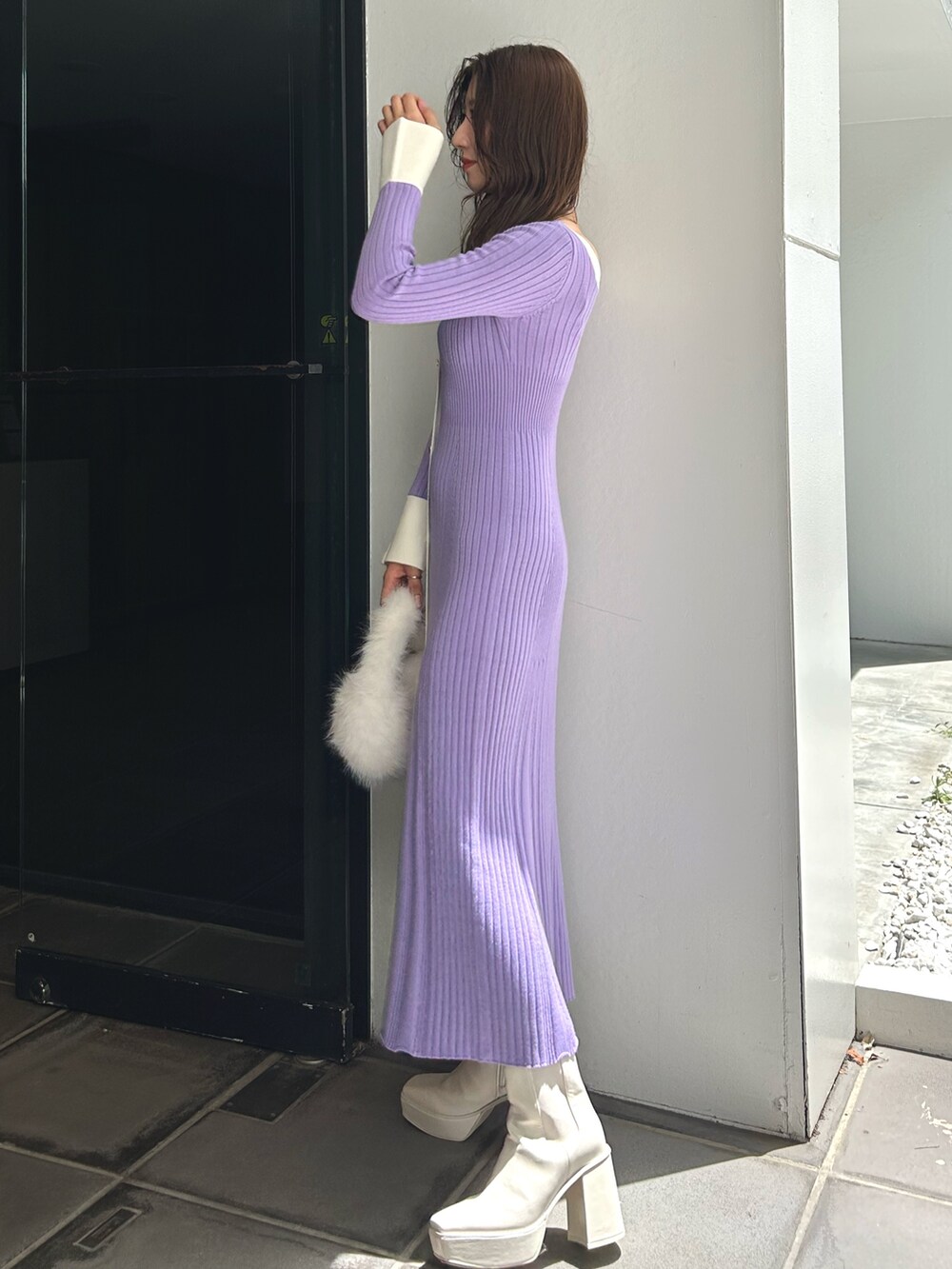 ホワイト系のハンドバッグ、ホワイト系のブーツ、パープル系のワンピースを着用したレディースの冬コーディネートの3枚目の写真