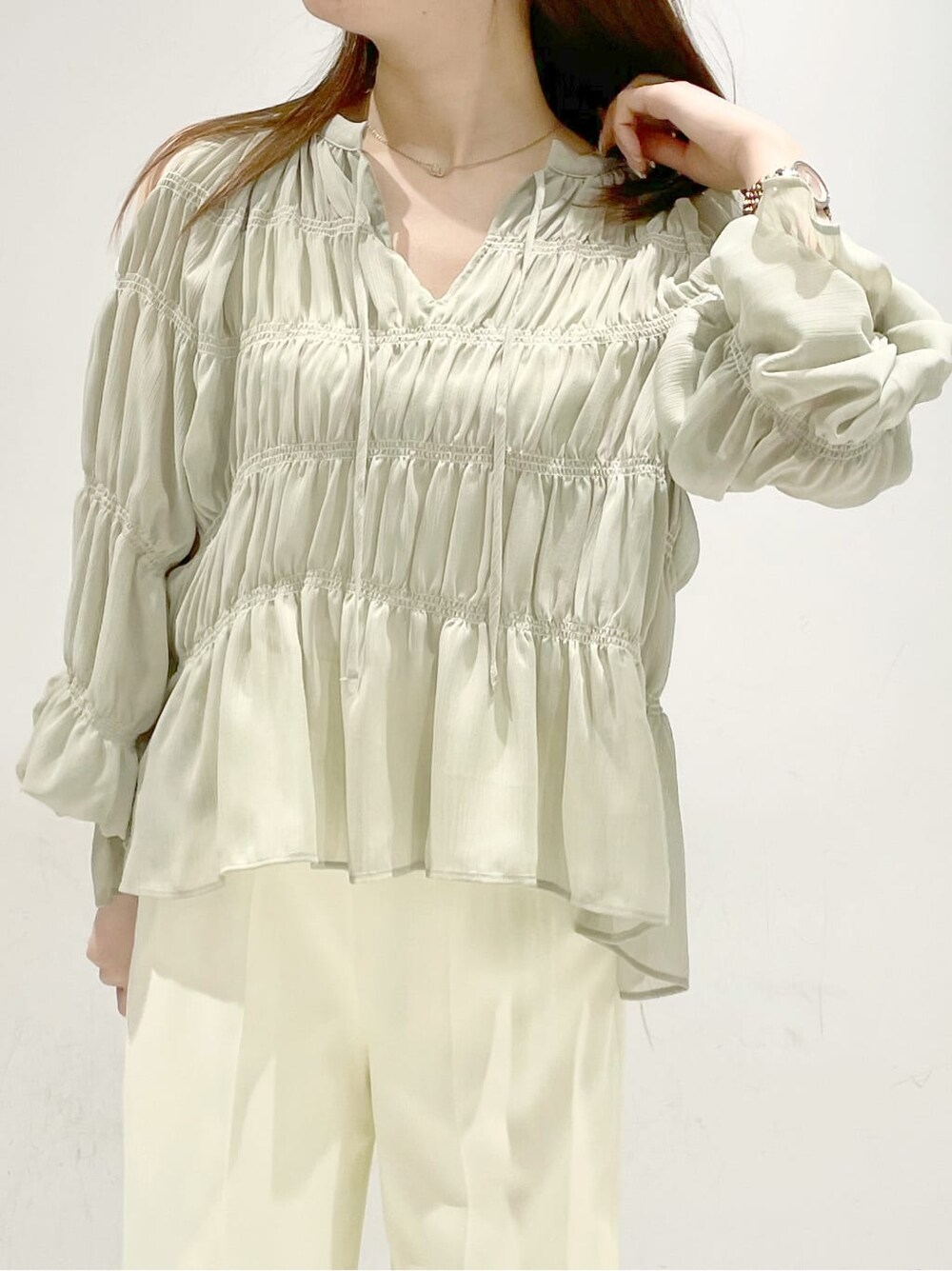 イエロー系のシャツ/ブラウス、ベージュ系のパンプス、イエロー系のショルダーバッグを着用したレディースの冬コーディネートの4枚目の写真