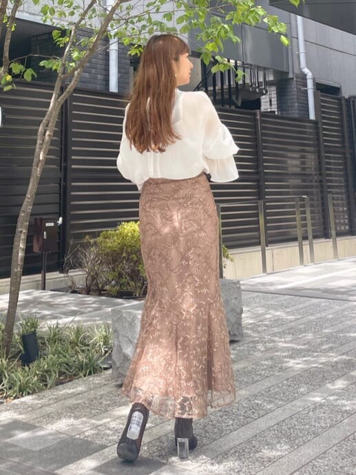 ブラウン系のスカート、ブラウン系のその他シューズ、ホワイト系のシャツ/ブラウスを着用したレディースの夏コーディネートの3枚目の写真