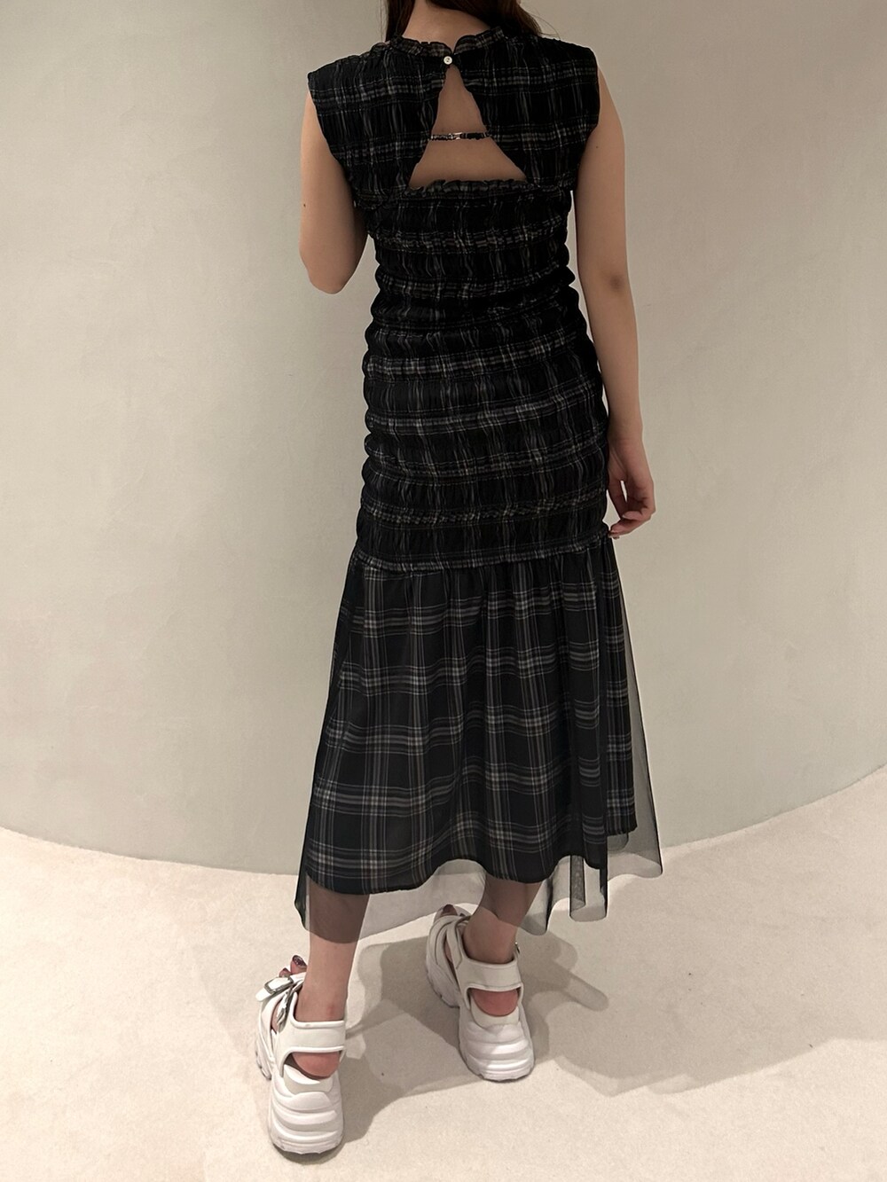 ブラック系のワンピース、ホワイト系のサンダルを着用したレディースの夏コーディネートの2枚目の写真