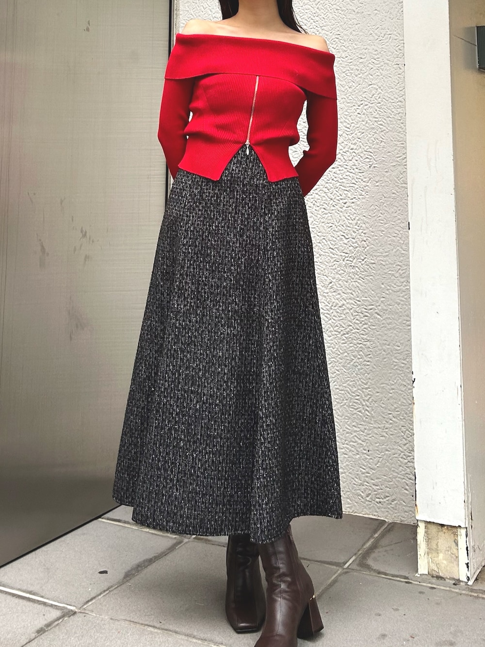 レッド系のニット/セーター、グレー系のその他アウター、ブラウン系のブーツを着用したレディースの冬コーディネートの3枚目の写真