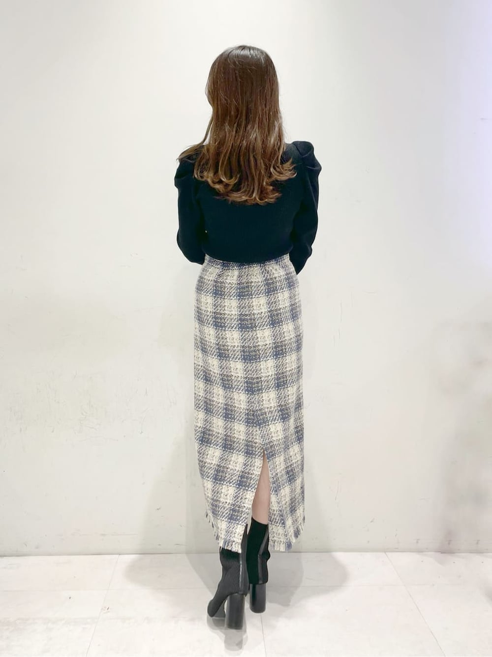 ブラック系のブーツ、ブルー系のスカート、ブラック系のニット/セーターを着用したレディースの冬コーディネートの3枚目の写真